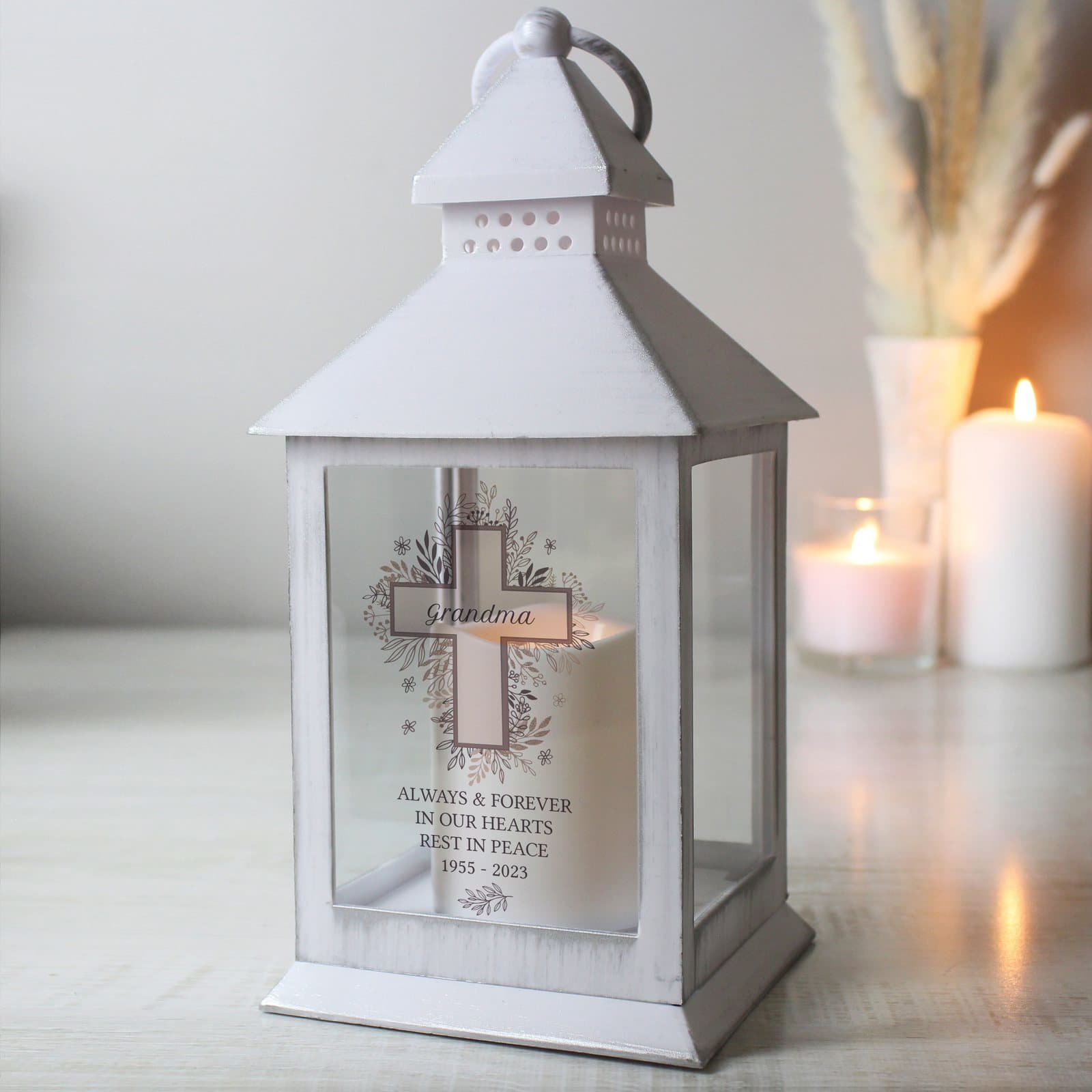 White floral cross lantern with a warm flame effect