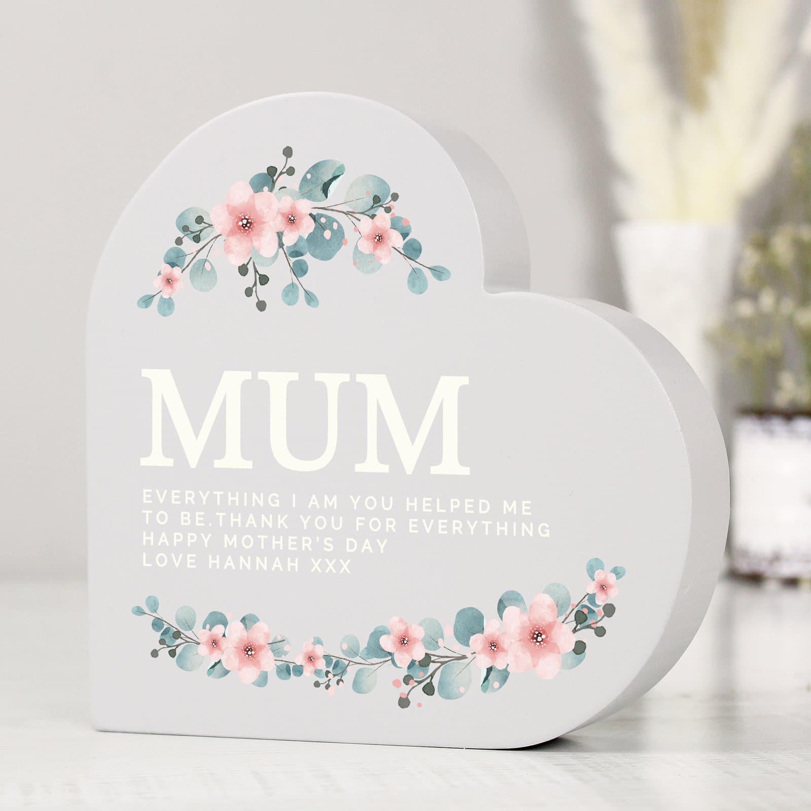 Grey painted wooden free standing heart with a floral design and text