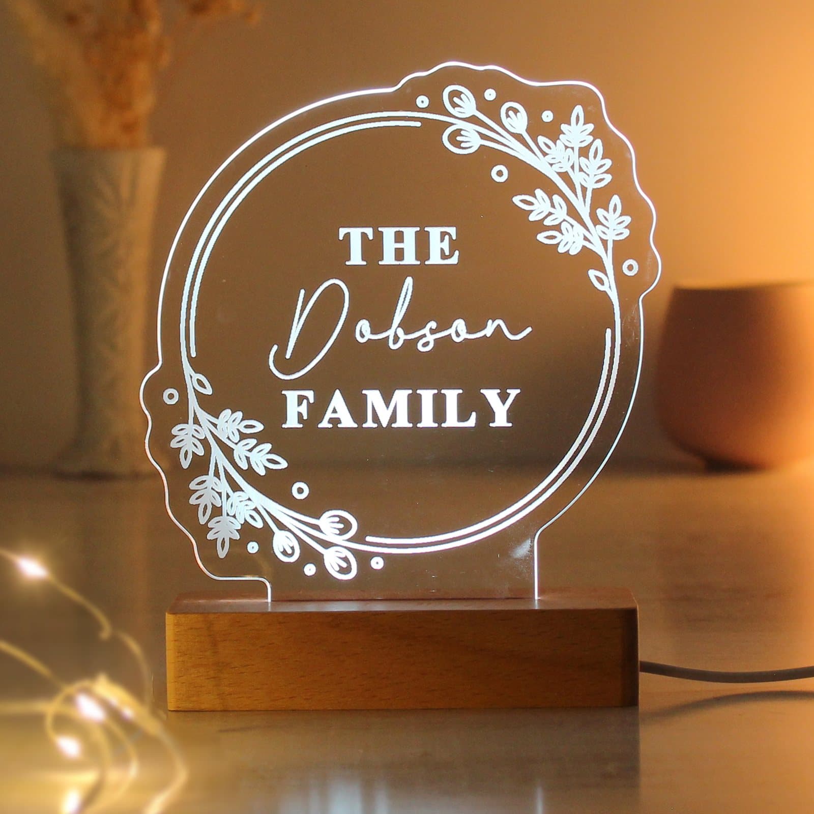 Personalised floral LED light sign on a wooden base with three lines of text