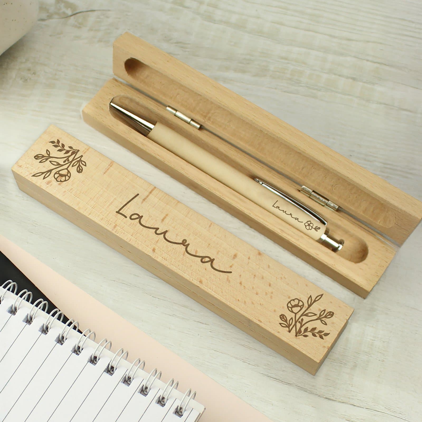 Floral wooden pen box with a blue ink pen and chrome clip