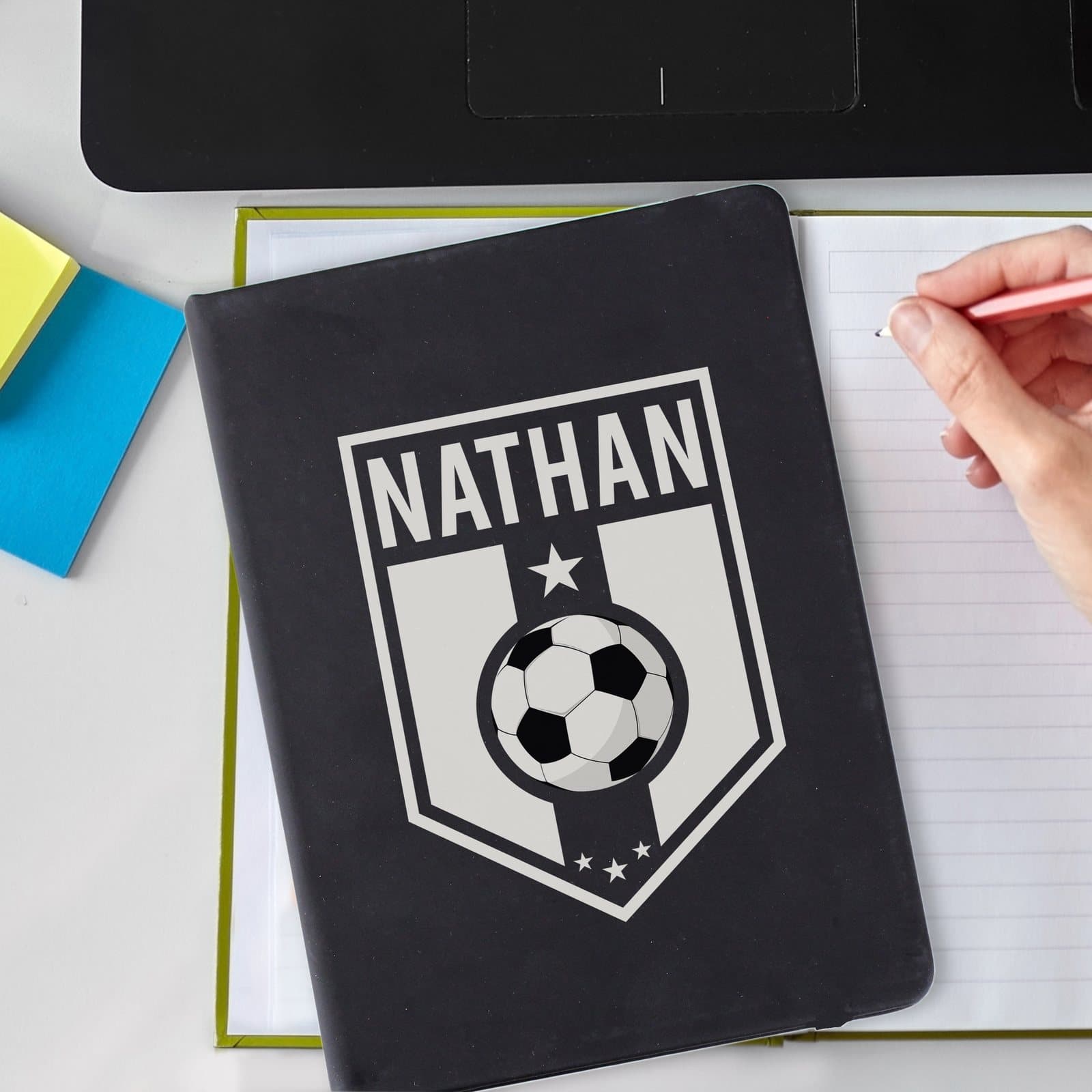 Black A5 notebook with a football themed badge for a personalised name