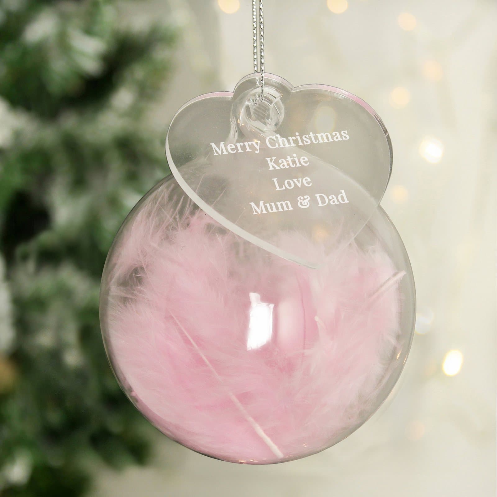 Glass bauble filled with a pink feather and an acrylic heart tag
