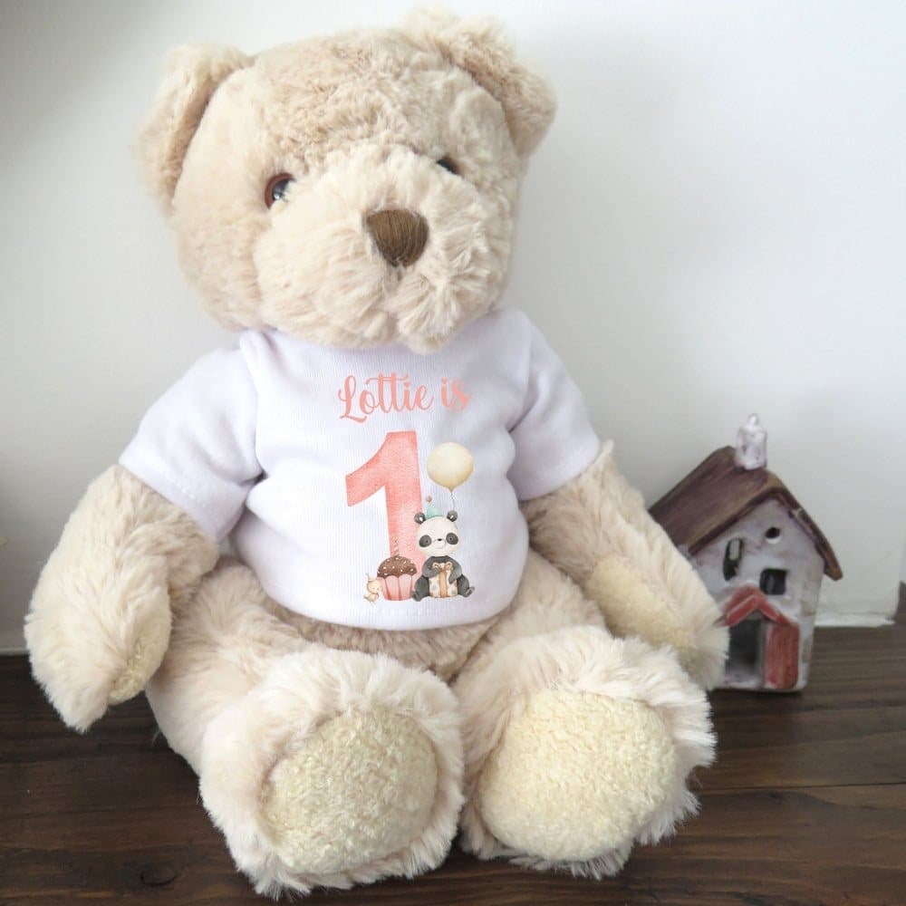 Teddy bear in a printed 1st birthday shirt with a large 1 and sweet animals