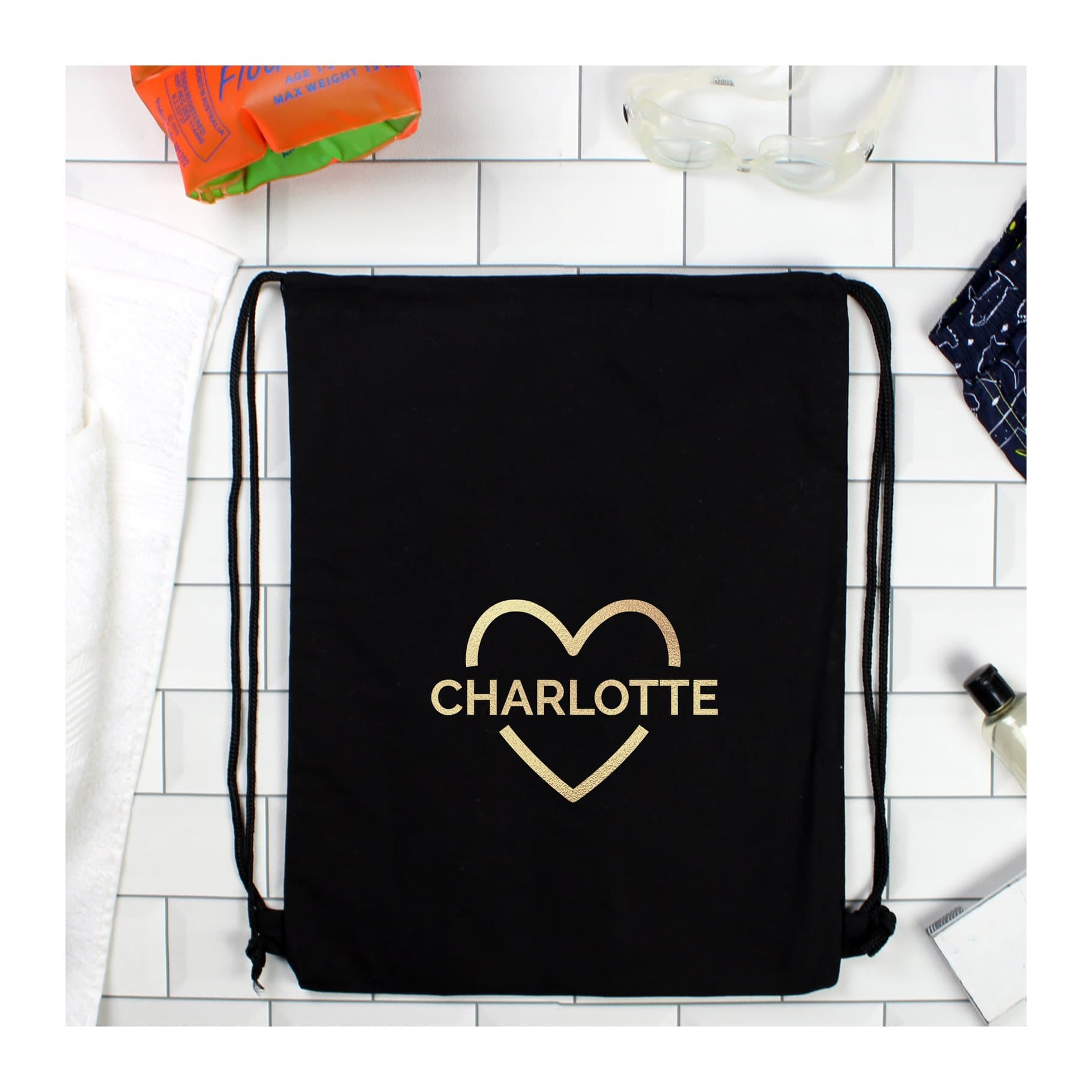 Black drawstring kit bag with a gold heart design