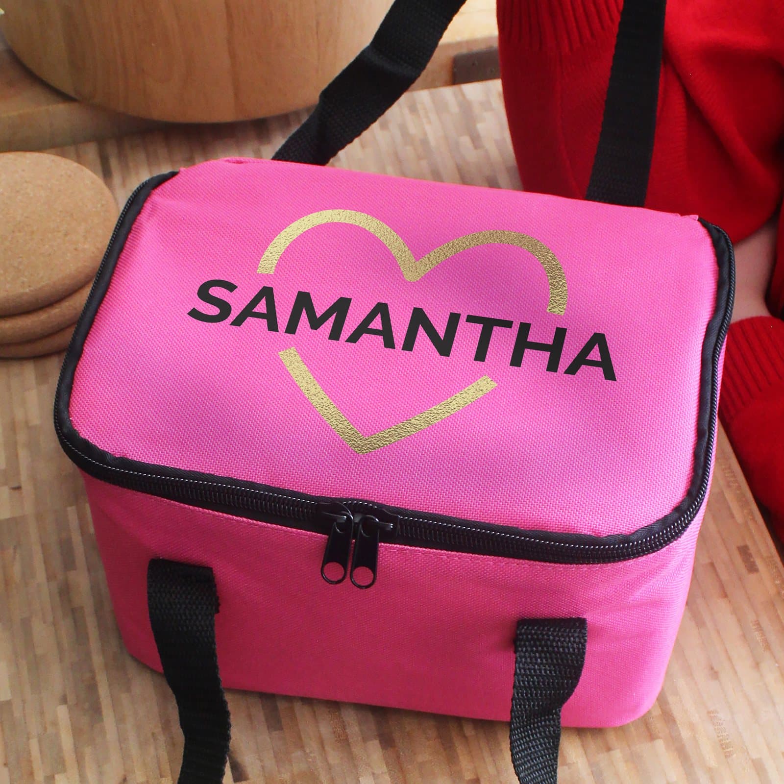 Pink lunch bag with a gold heart design and two carry straps