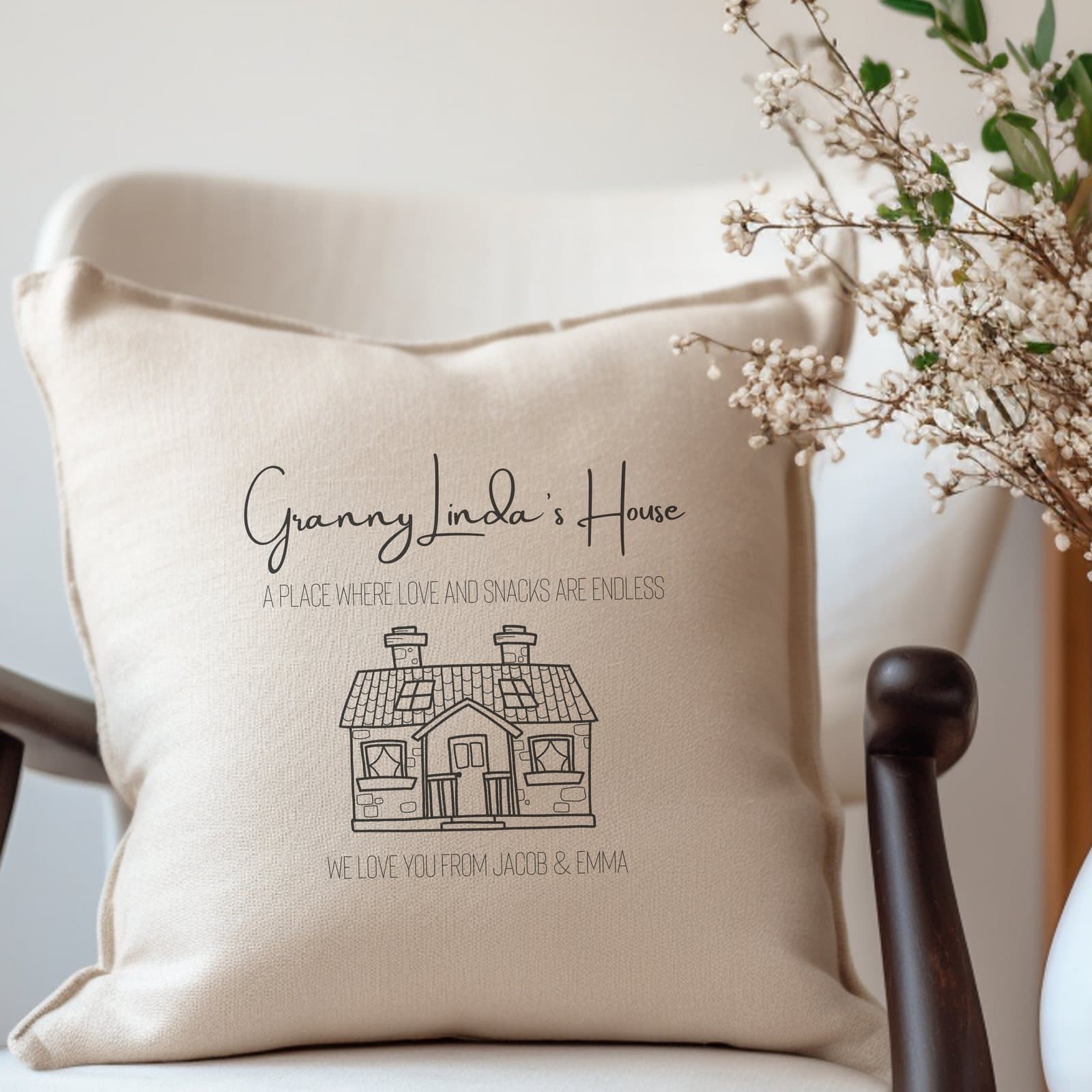 Cream cushion with a cute house and 'A place where love and snacks are endless'.