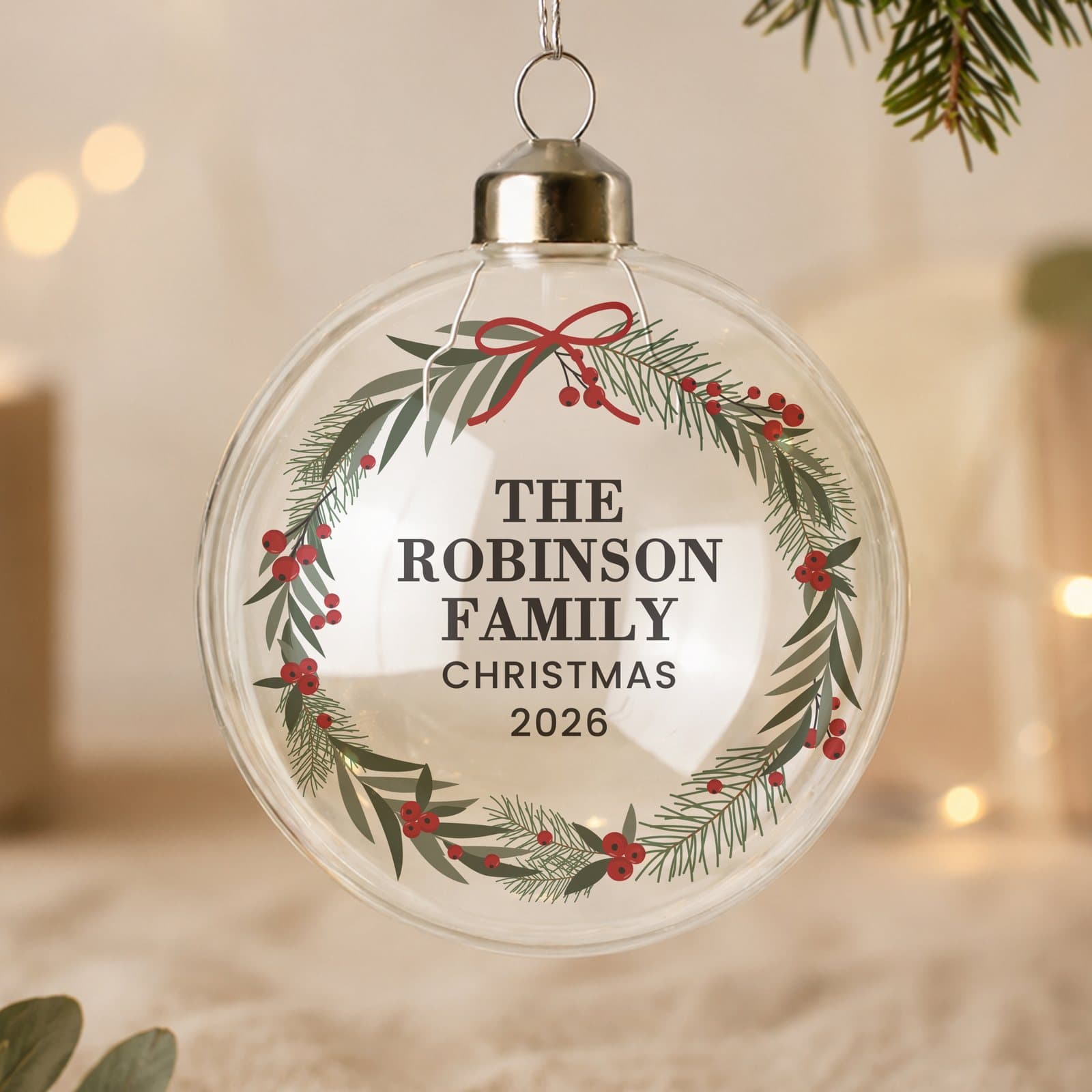 Glass Christmas bauble with a green wreath design and a ribbon
