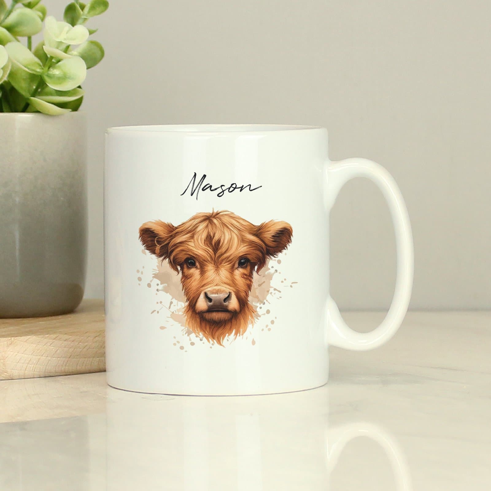 Personalised ceramic mug with a Highland cow design and a name above it