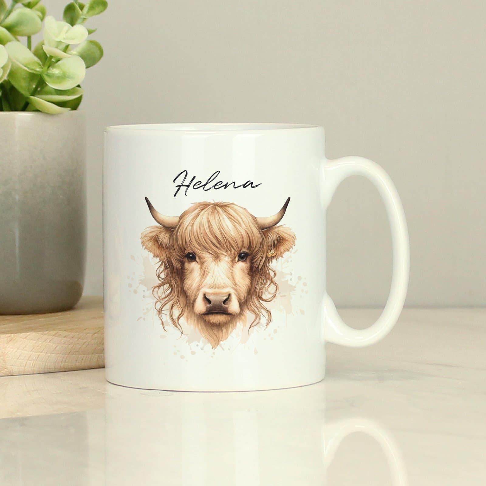 Personalised ceramic mug with a Highland cow design and a name above it