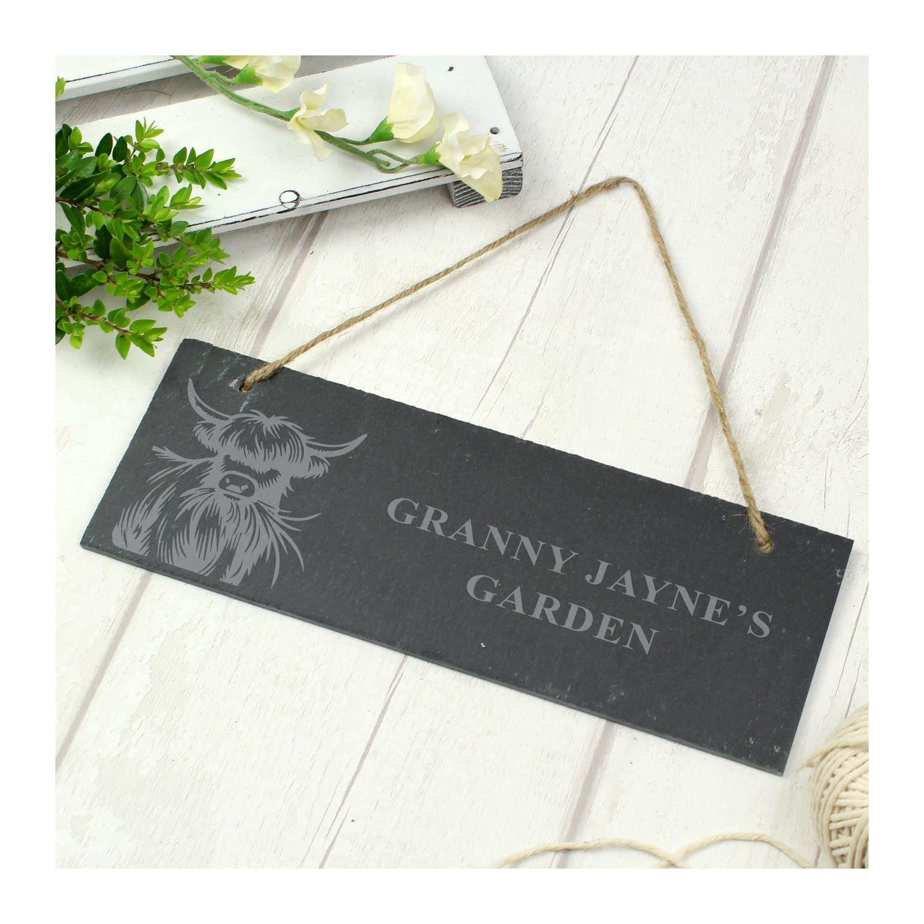 Slate sign with an engraved Highland cow design and two lines of text