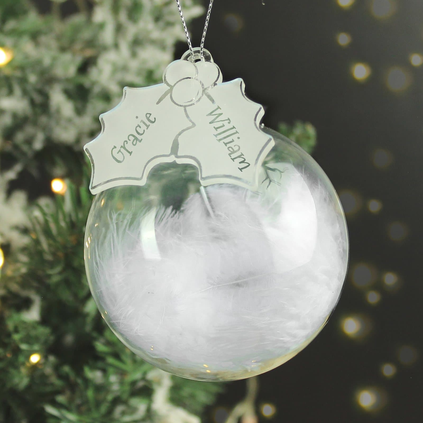 Glass bauble filled with a white feather and an acrylic holly tag