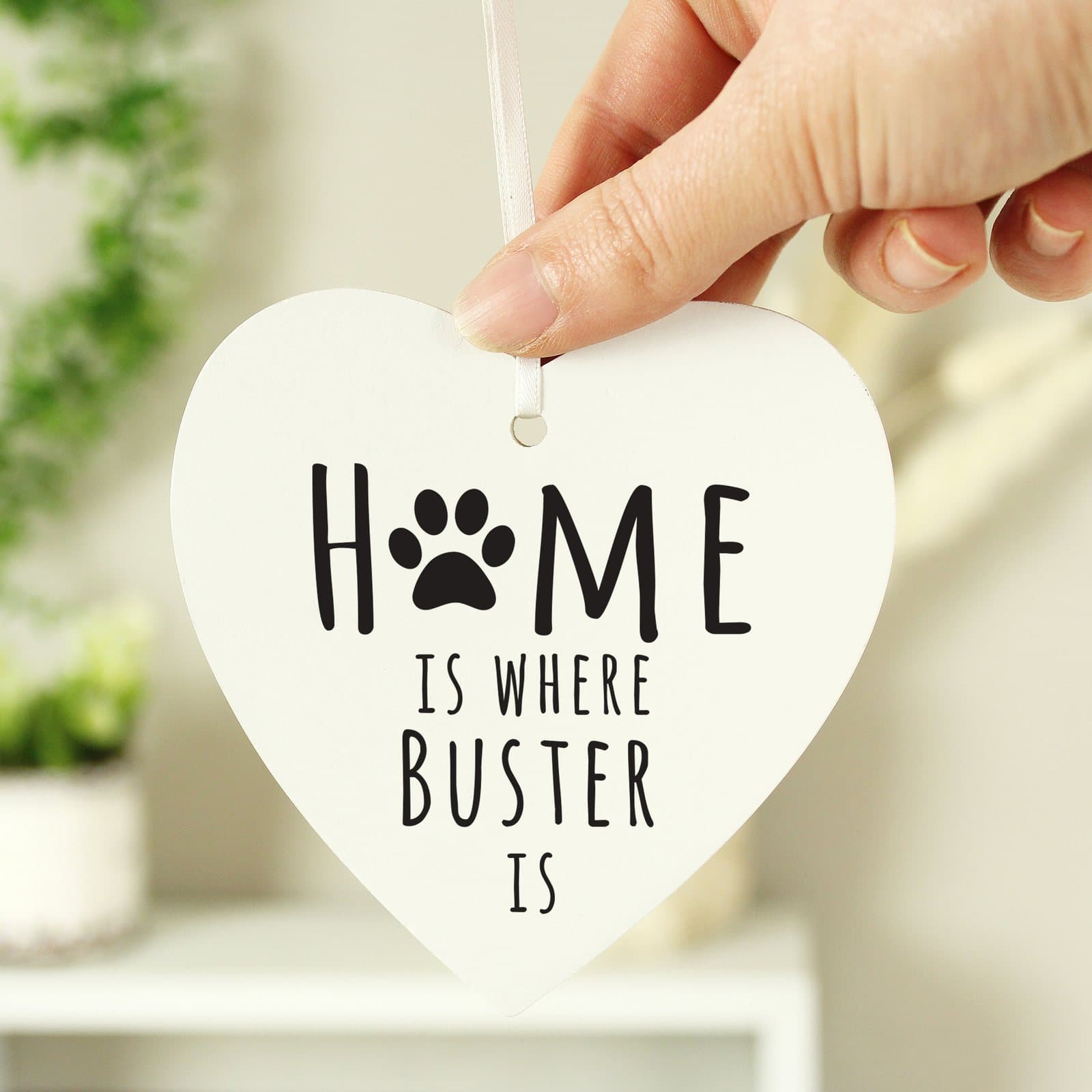 Wooden heart decoration reading Home is where with a pet's name and a ribbon
