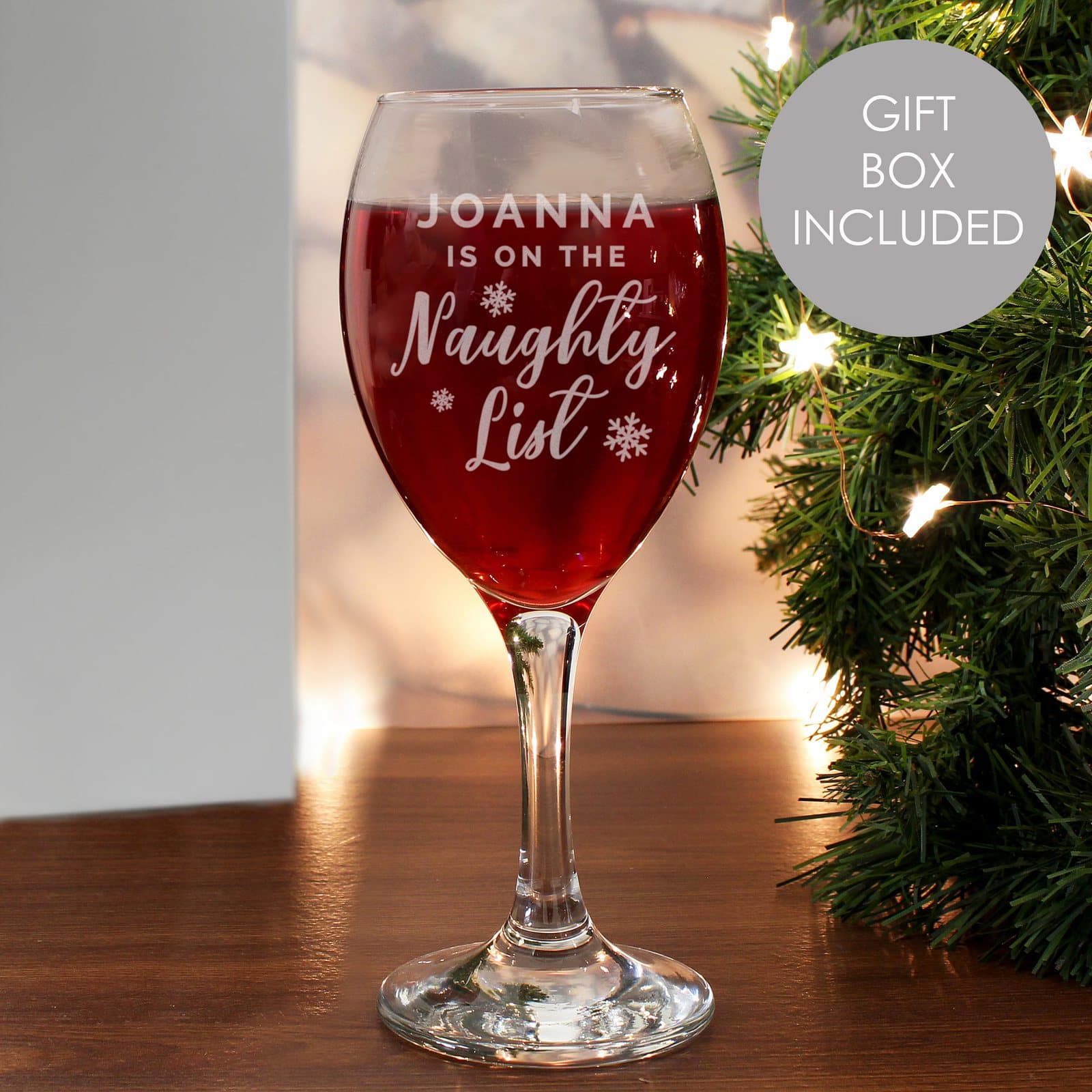 Wine glass with a name and the words is on the naughty list