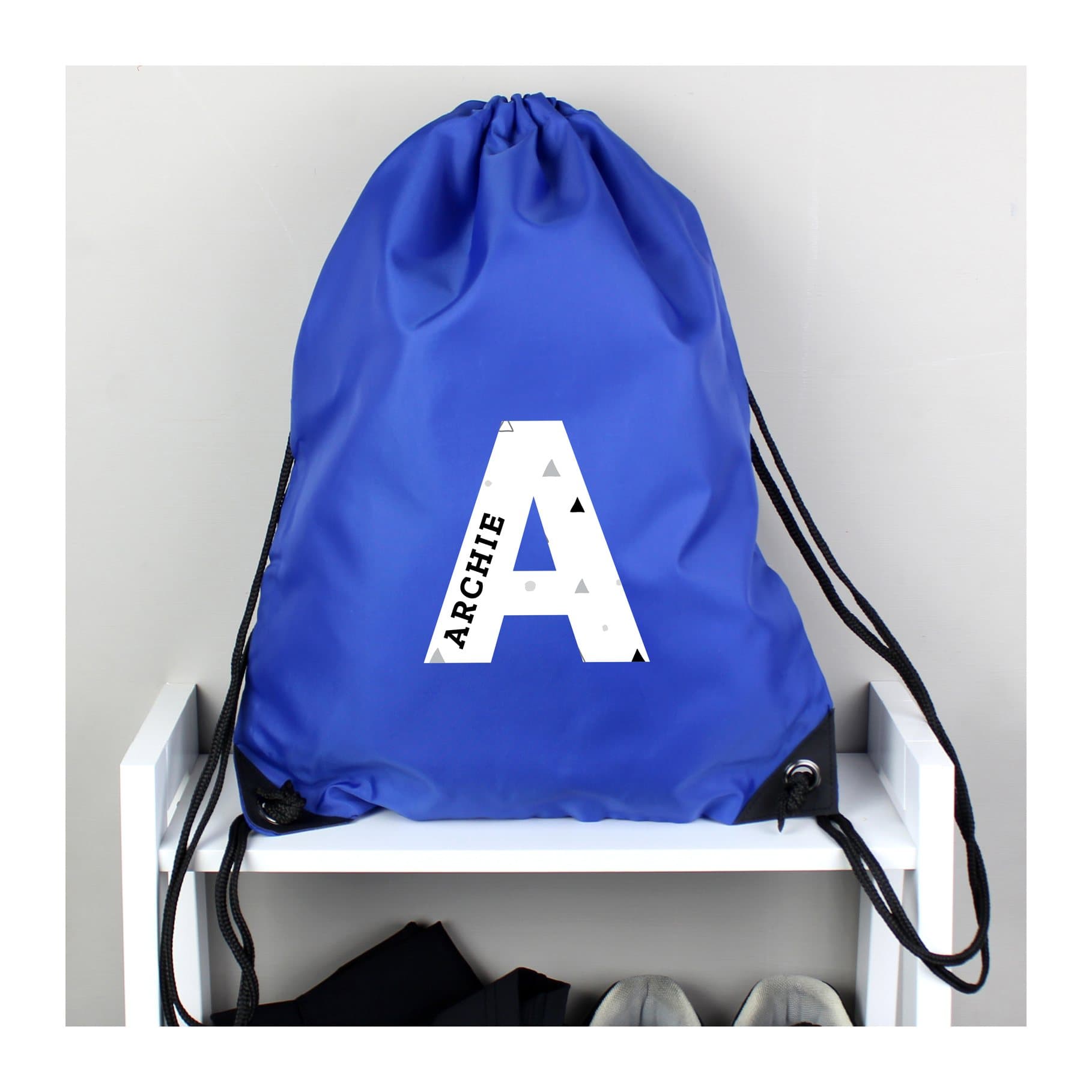 Blue drawstring kit bag with a name inside a large initial
