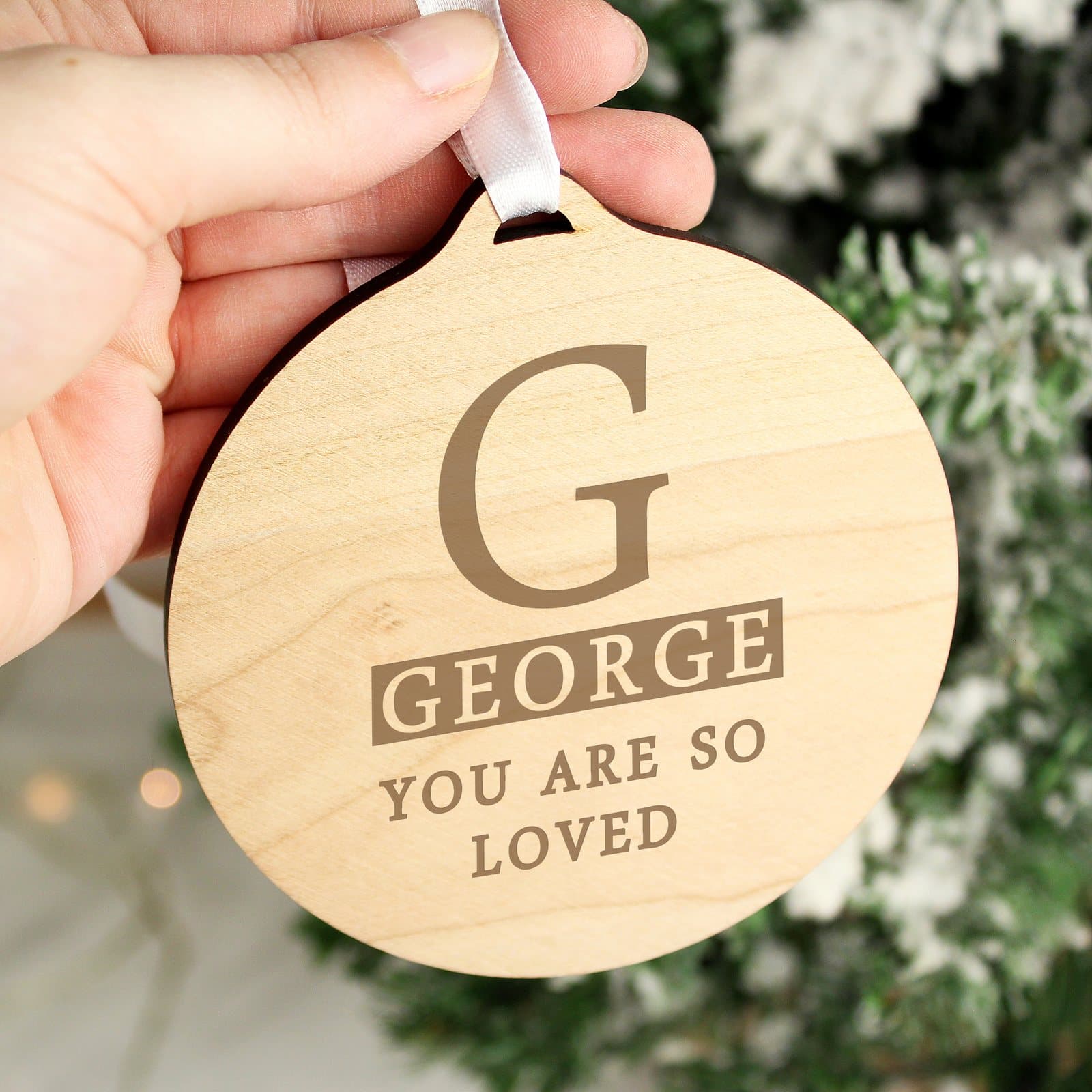 Round wooden decoration with personalised initial and ribbon