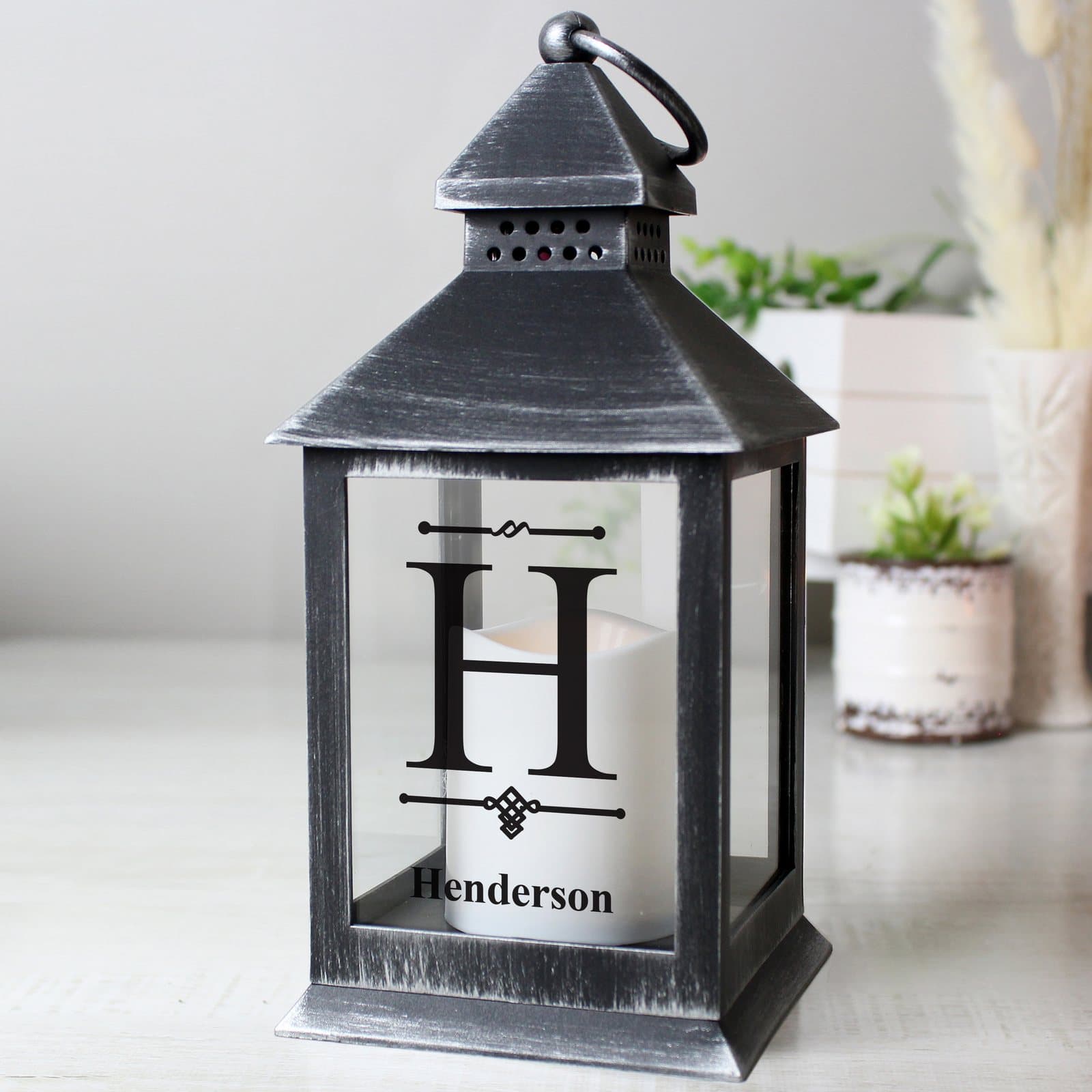 Rustic black lantern with a flickering orange flame effect and a hoop