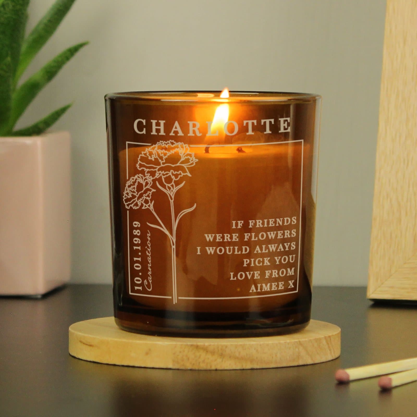 Amber glass candle jar with a January birth flower design and personalised text