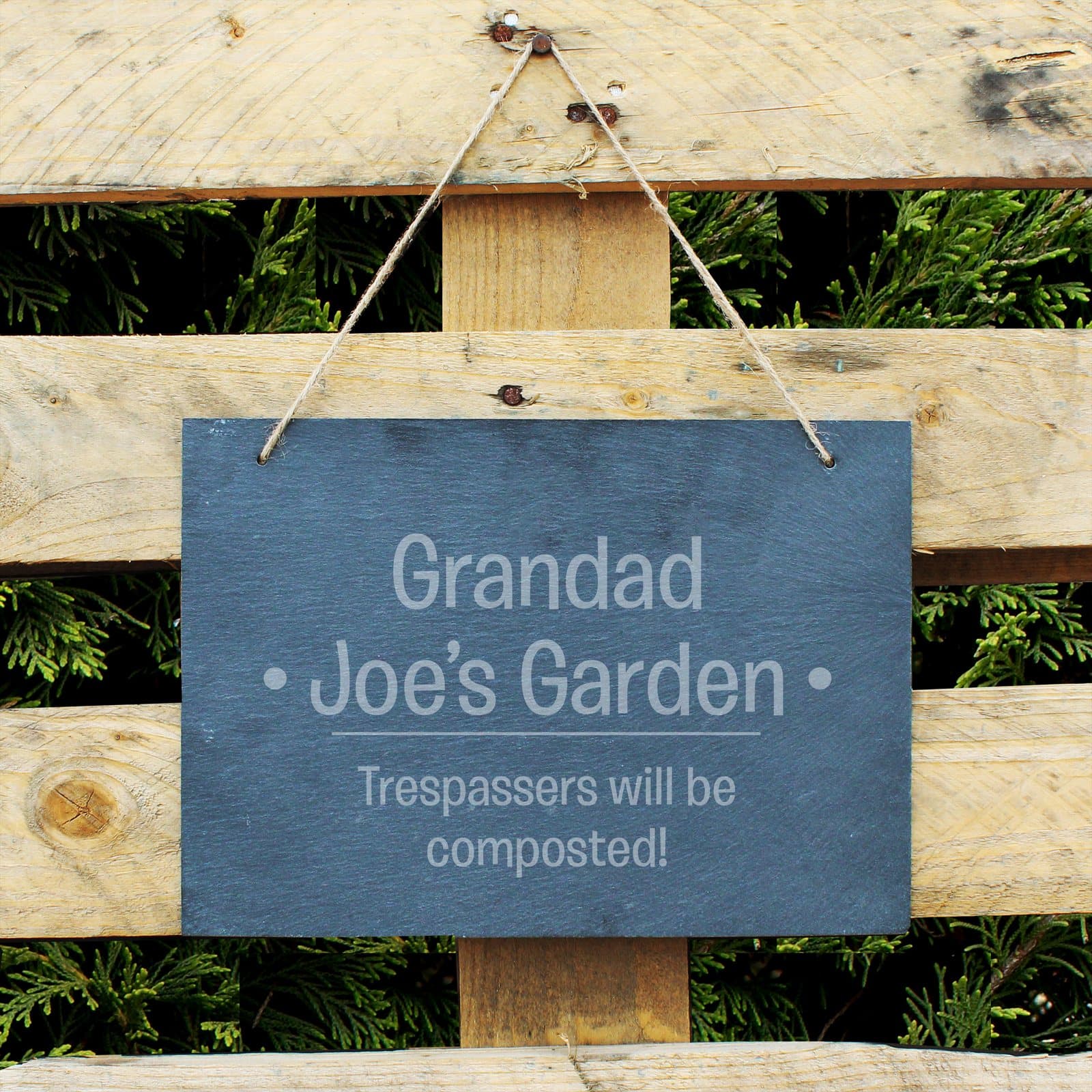 Large hanging slate sign with two bold lines and two smaller lines of text