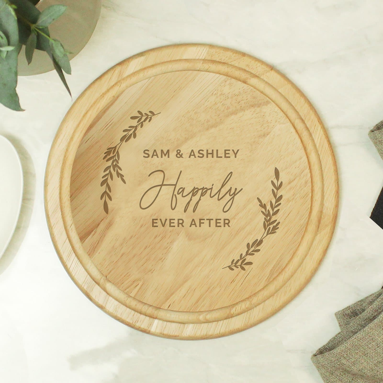 Round natural wood chopping board engraved with a three-line message