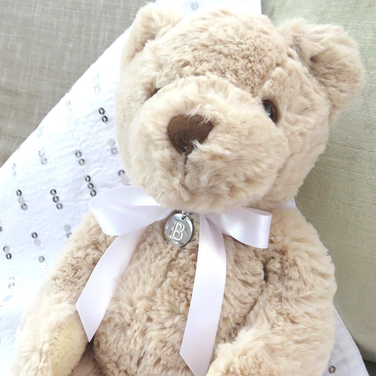 Personalised teddy bear with a stainless steel disc on a white satin ribbon