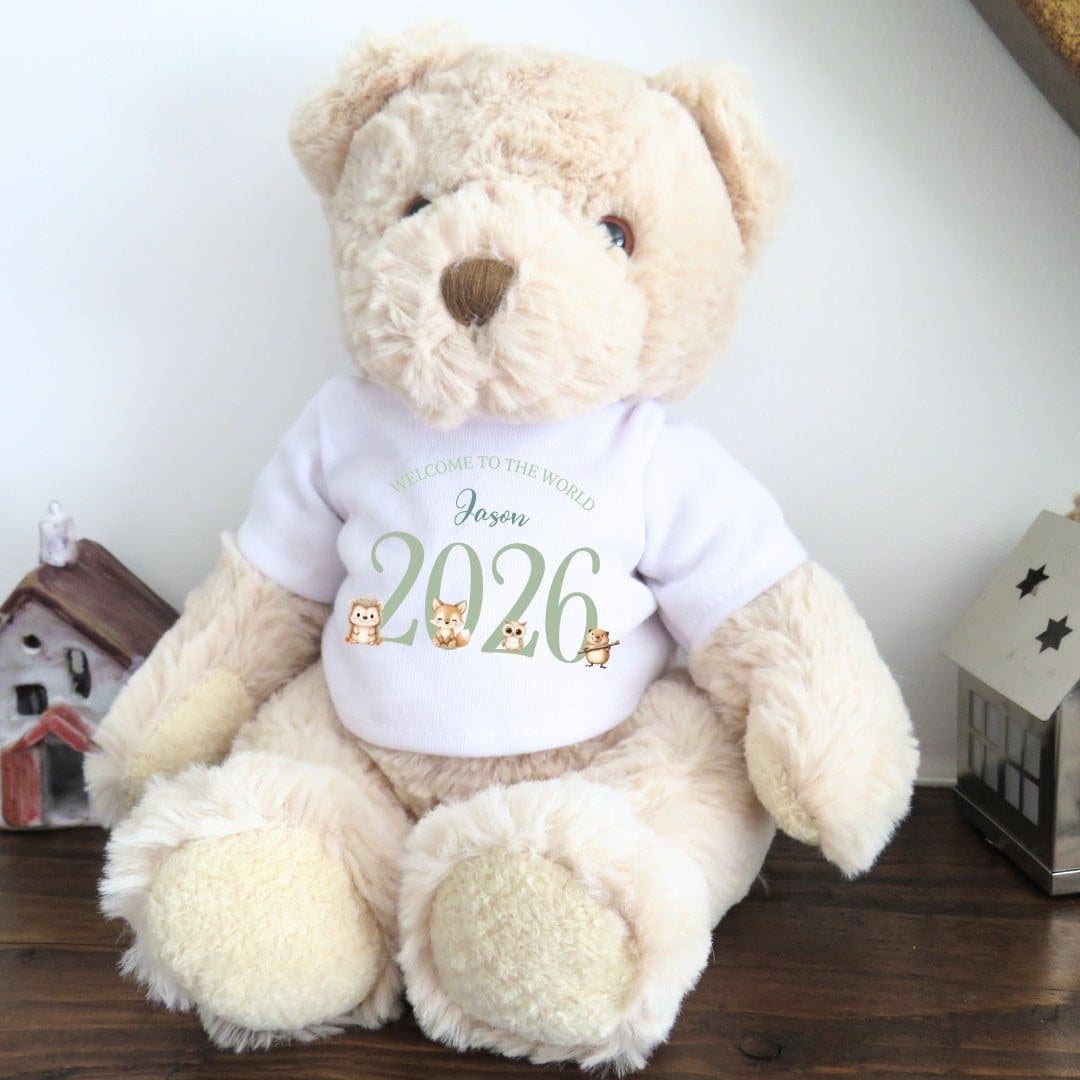 Teddy bear in a woodland animal T-shirt with 2026 Welcome to the World design