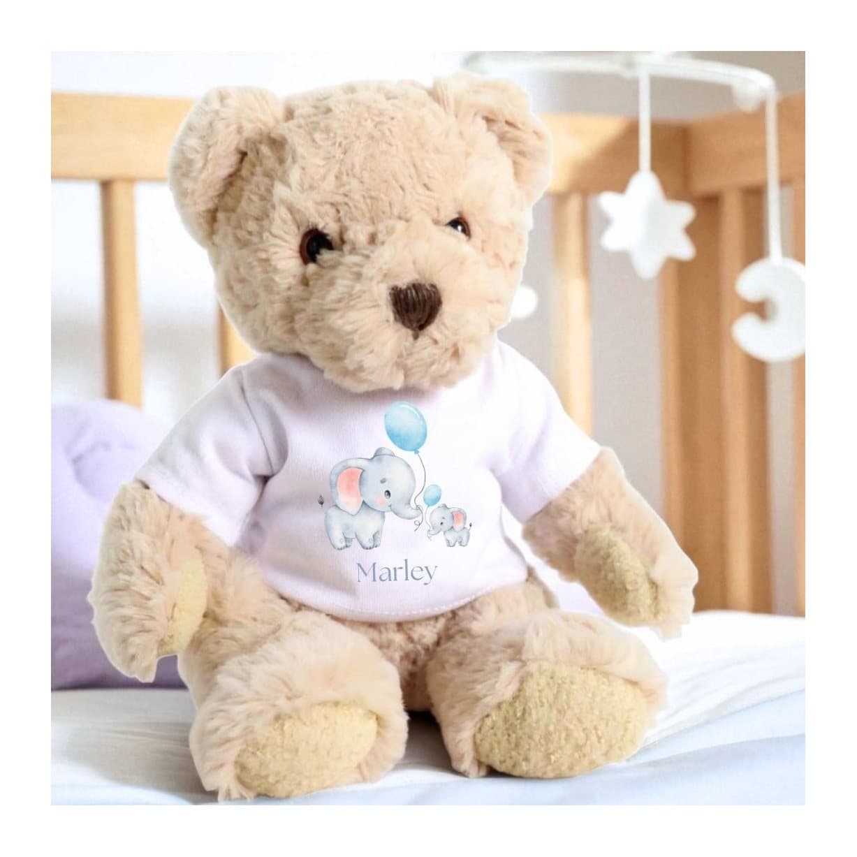 Teddy bear in a T-shirt with two elephants holding blue balloons
