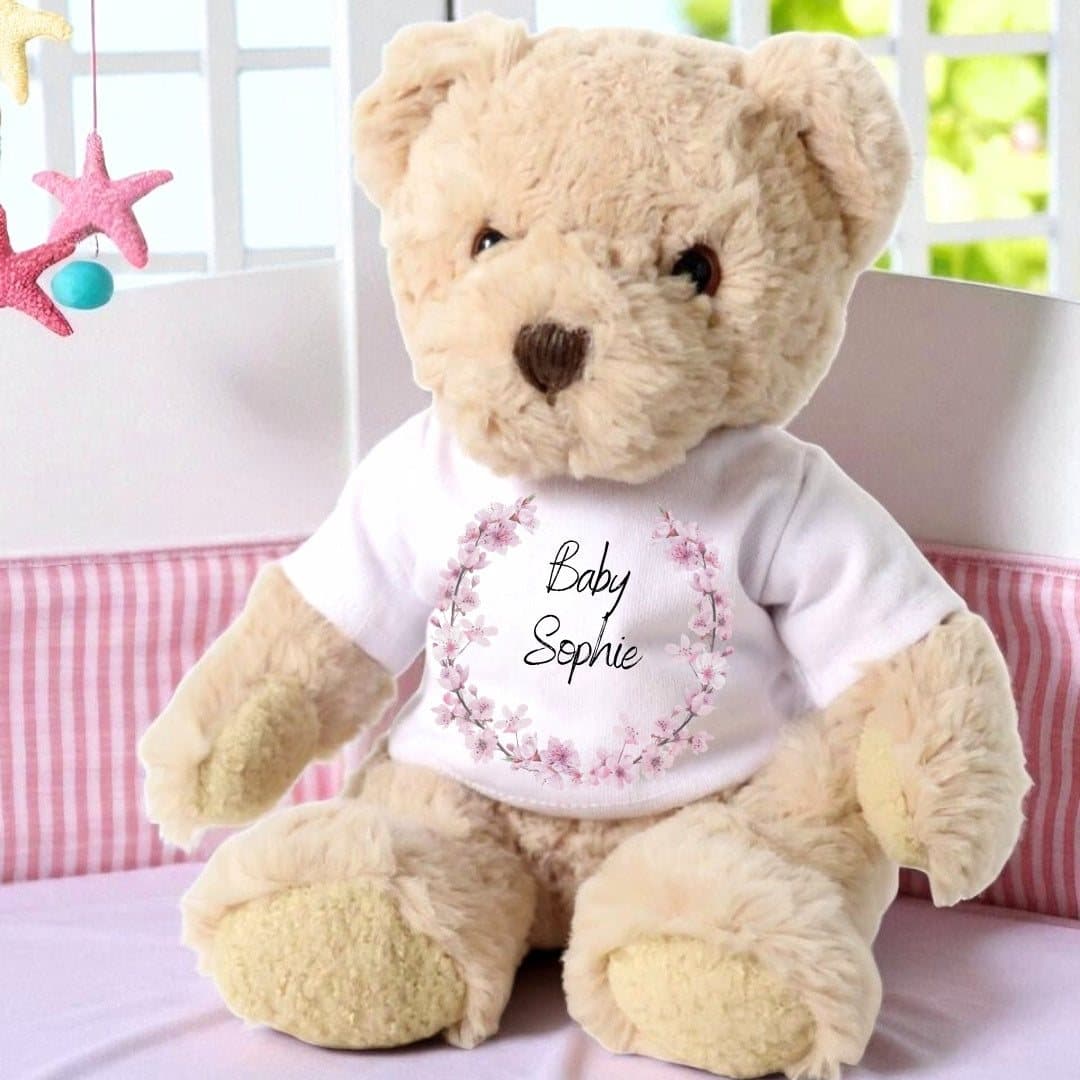 Teddy bear wearing a pink blossom T-shirt with a name printed in the centre