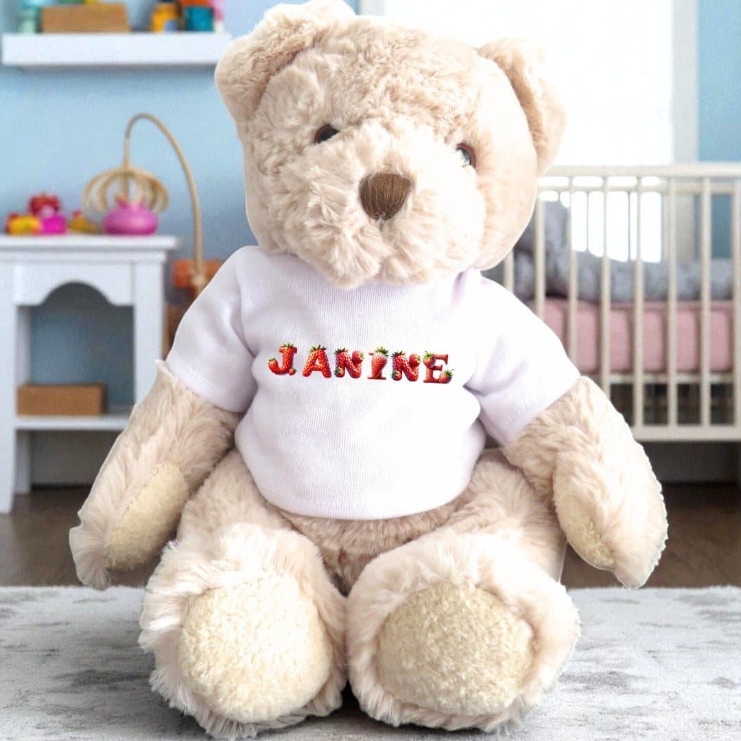 Teddy bear wearing a T-shirt with a strawberry design and a name printed on it.