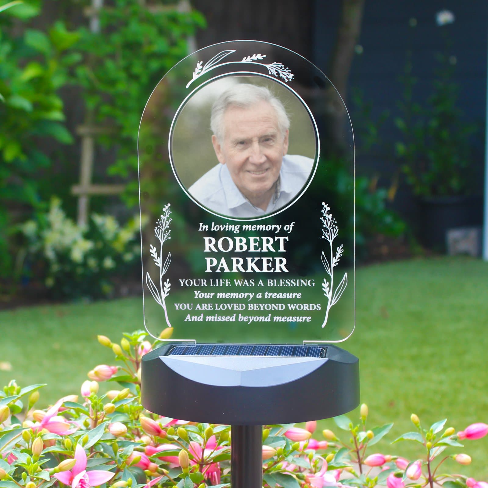 Outdoor solar memorial light sign with a photo and lines of text