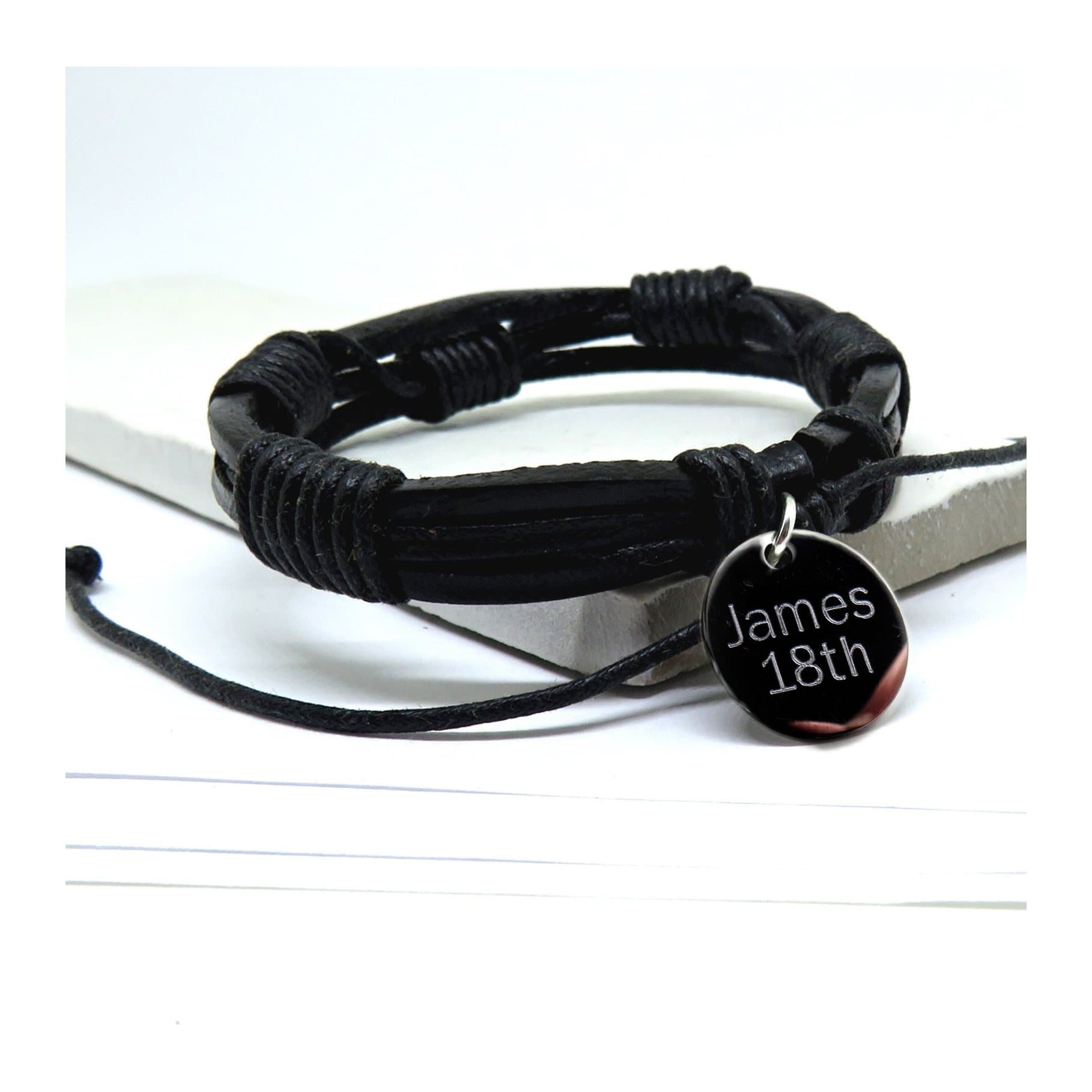 Black multi-strand leather and cord bracelet with a silver coloured disc