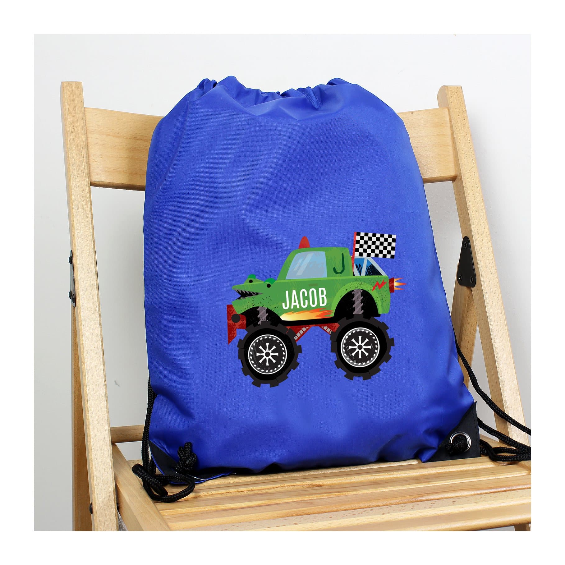 Blue monster truck kit bag with a drawstring and a name on the truck