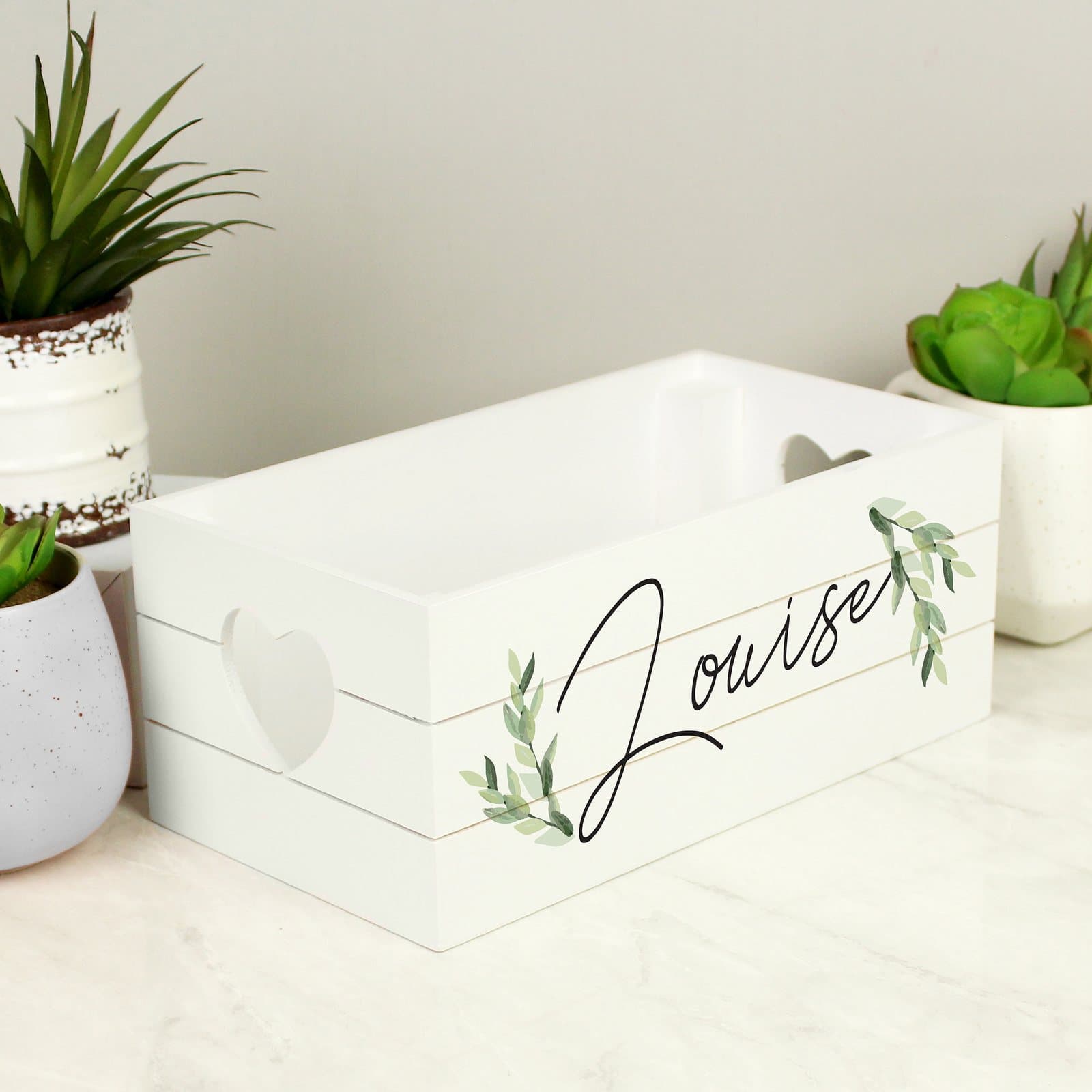 White wooden crate with heart shaped handles and a name