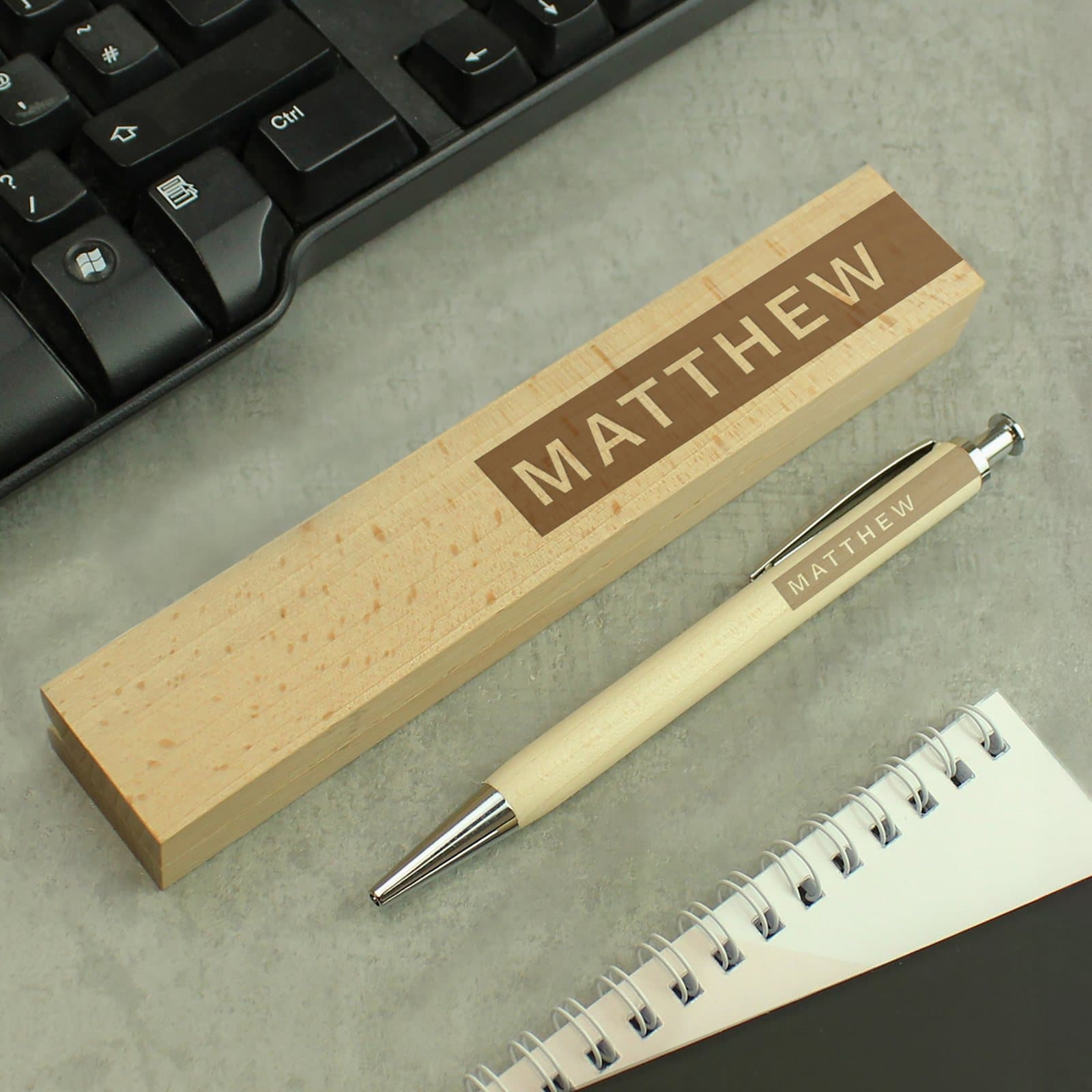 Wooden pen with chrome clip beside a beechwood box, personalised