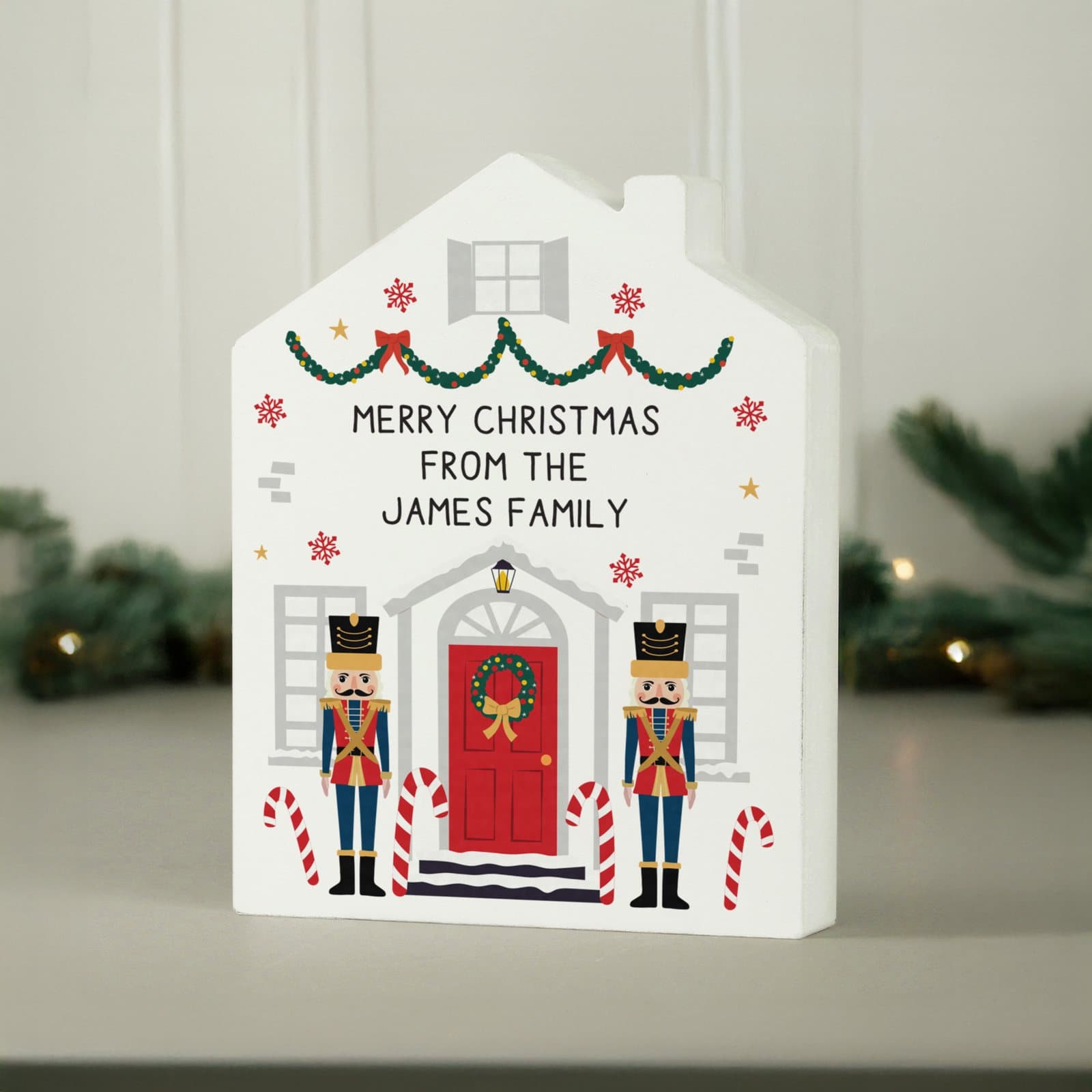 Wooden nutcracker soldier guarding a little house ornament with personalised text