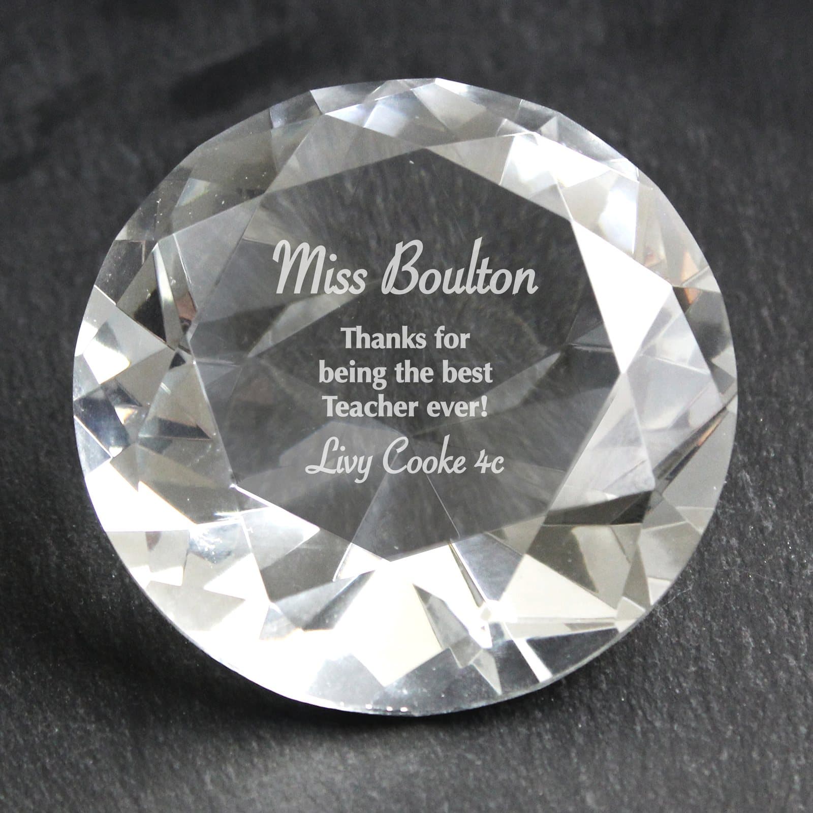 Diamond paperweight with a personalised message beside a black silk style lined box