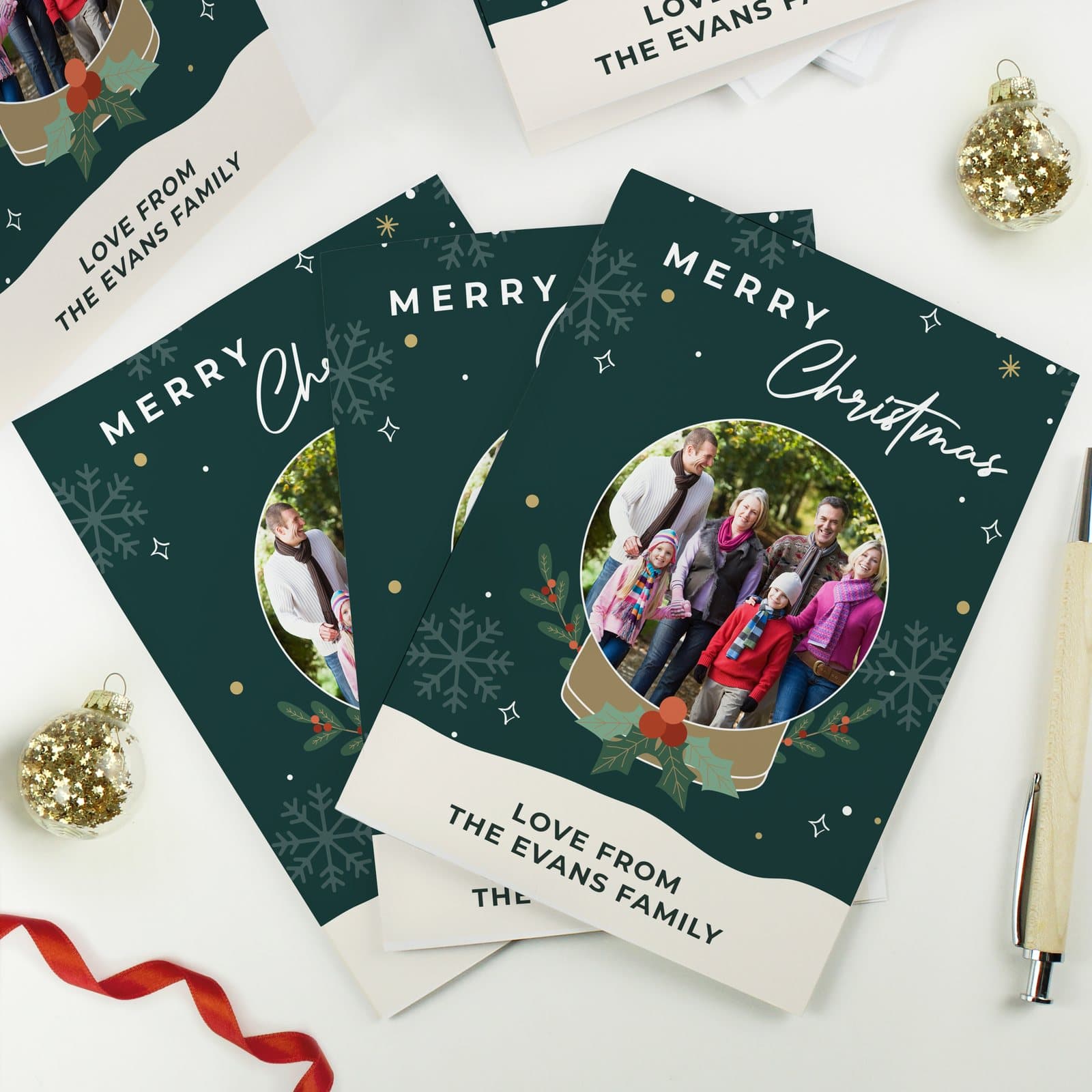 Pack of Christmas cards with a snow globe design and white envelopes