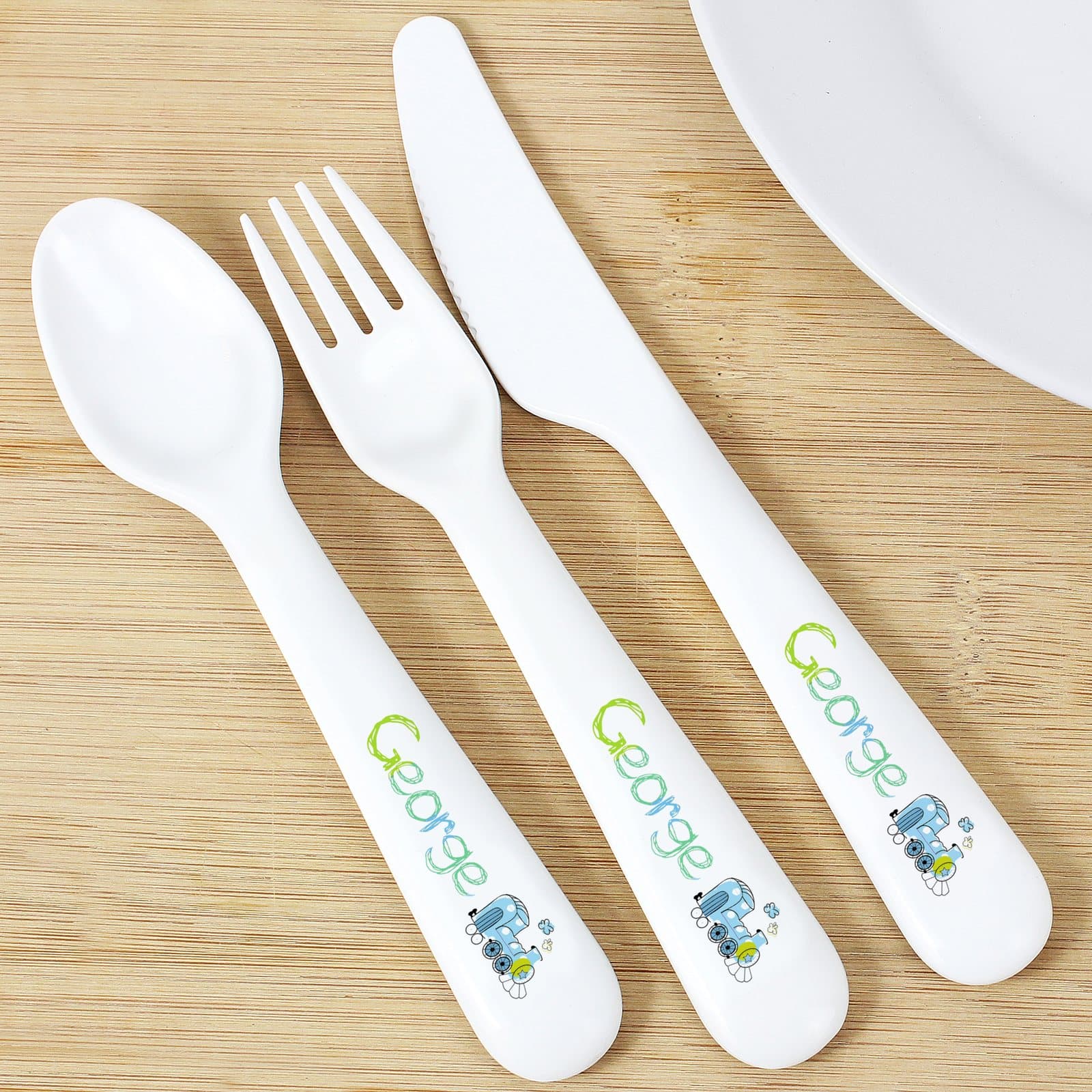 Plastic spoon, knife and fork with a patchwork train design and name