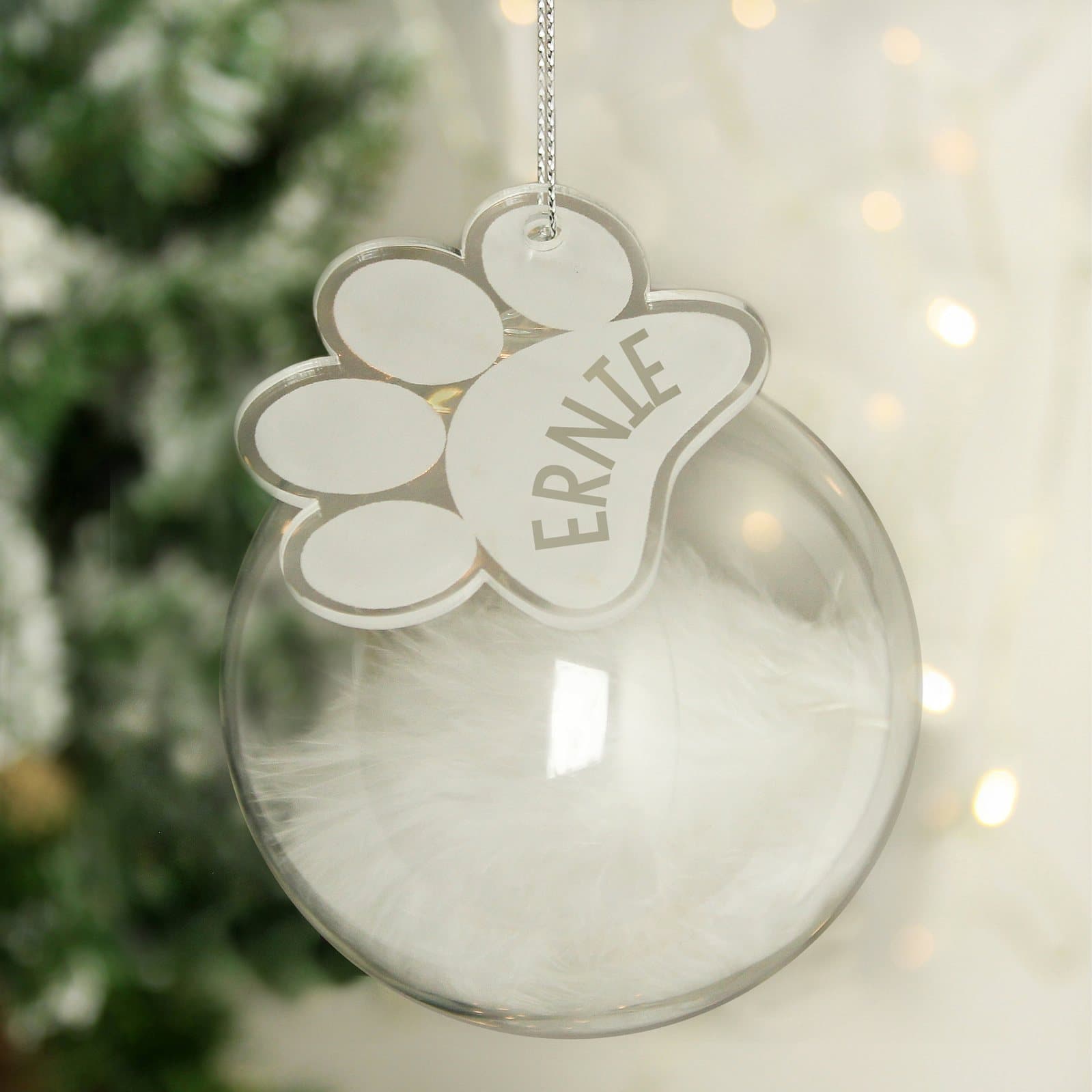 Glass bauble filled with a white feather and an acrylic paw print tag