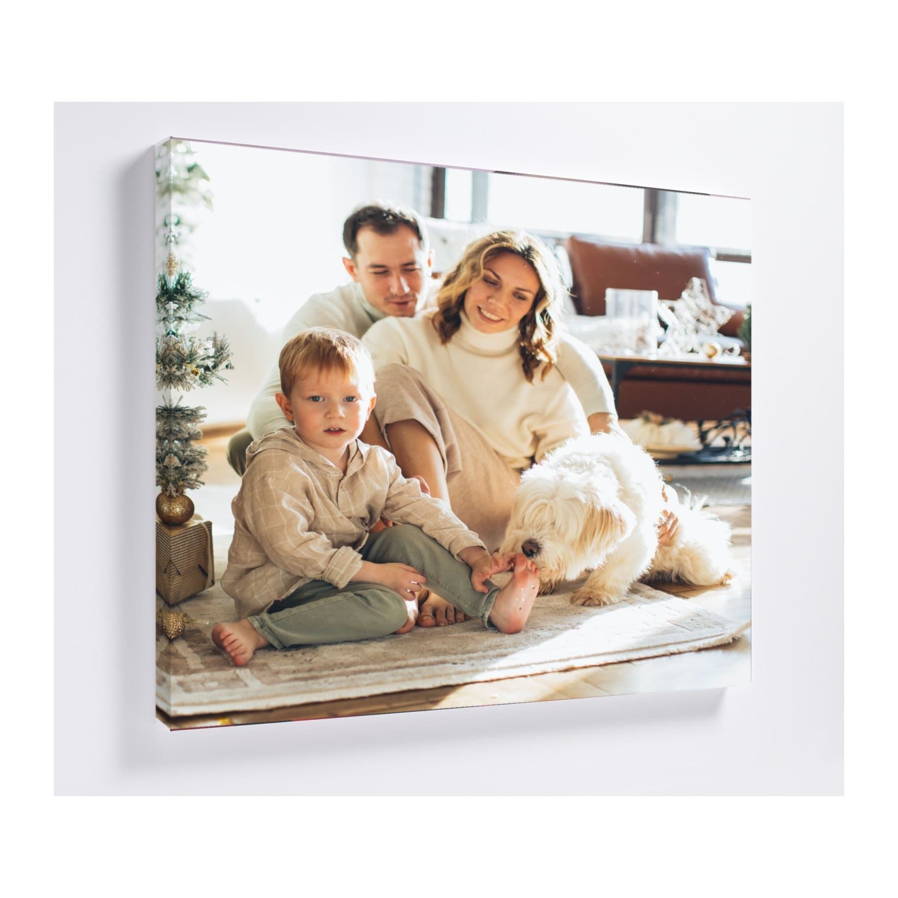 Square canvas on a wall printed with a family photo by a Christmas tree