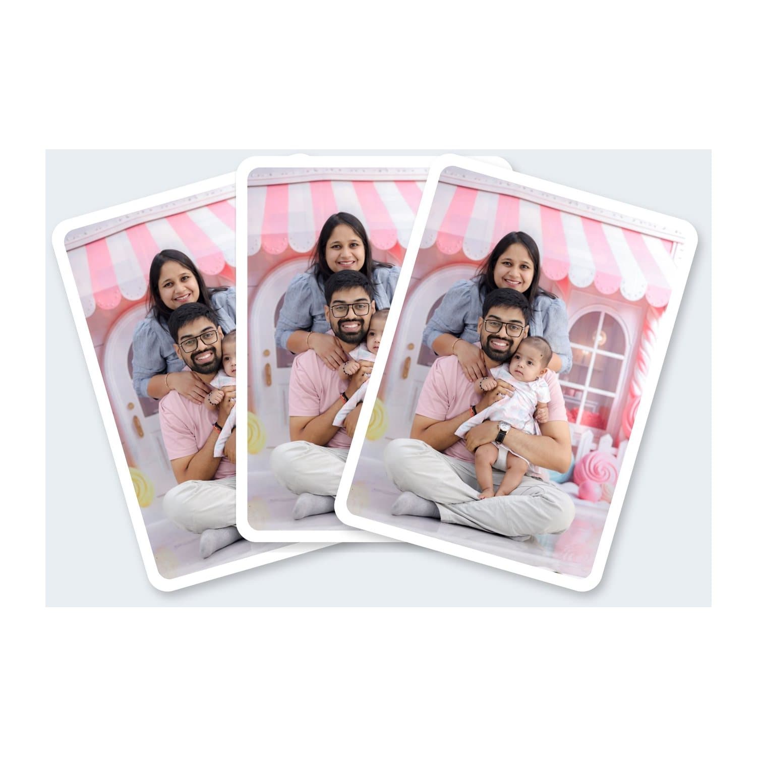 Three playing cards fanned out, each printed with a family photo