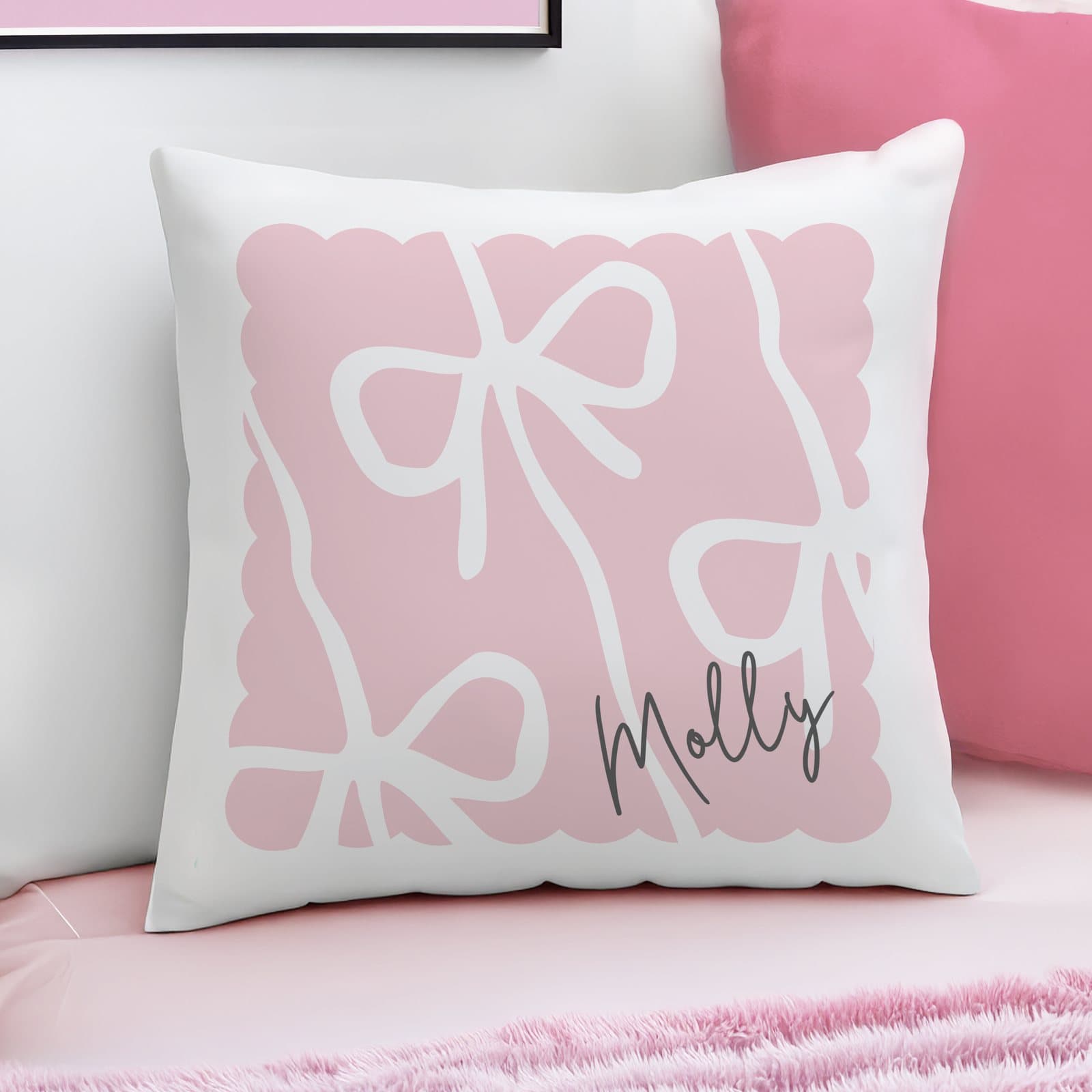Pink cushion with a bow design and a personalised name in script font