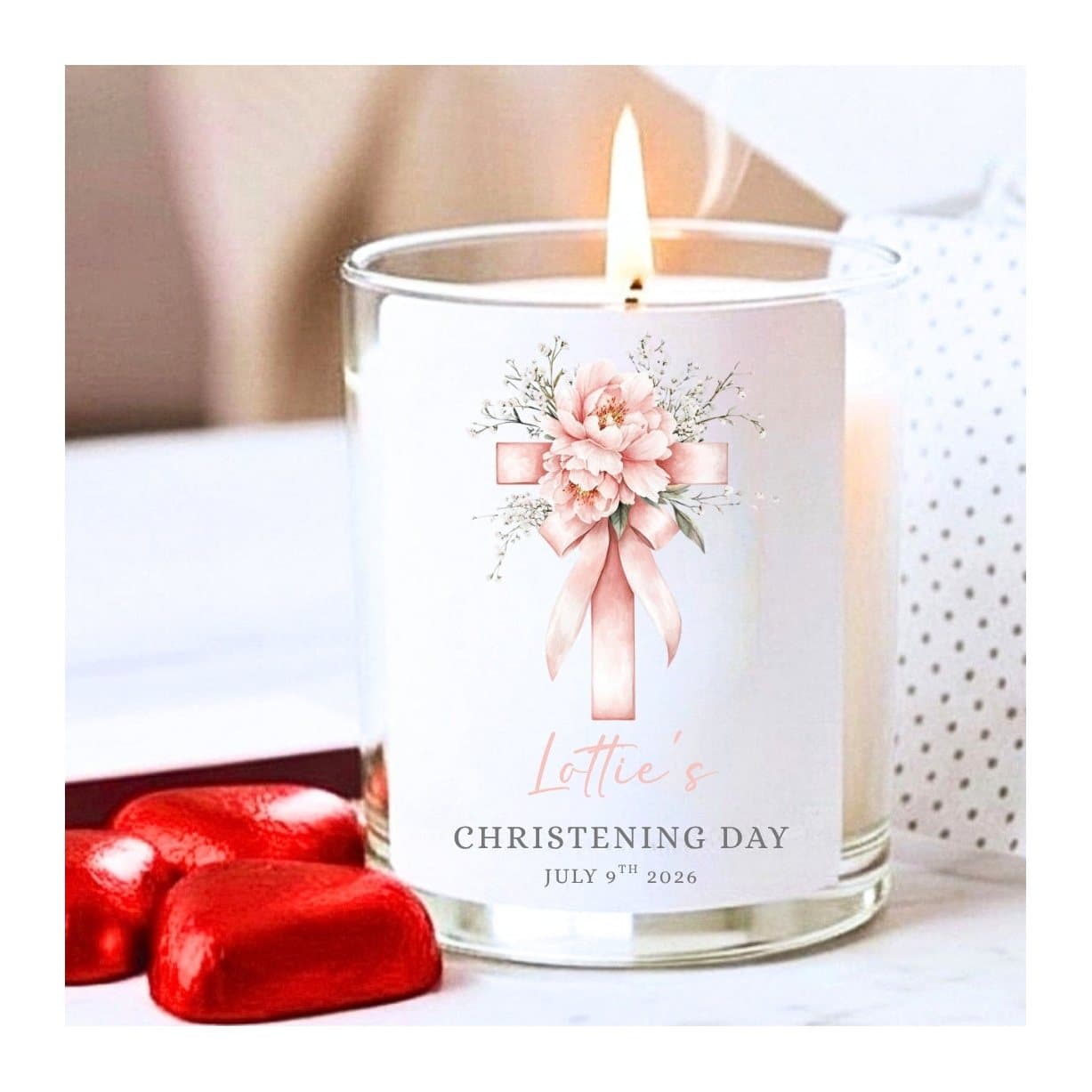 Pink christening candle with a cross and pink flowers design, with chocolates and matches