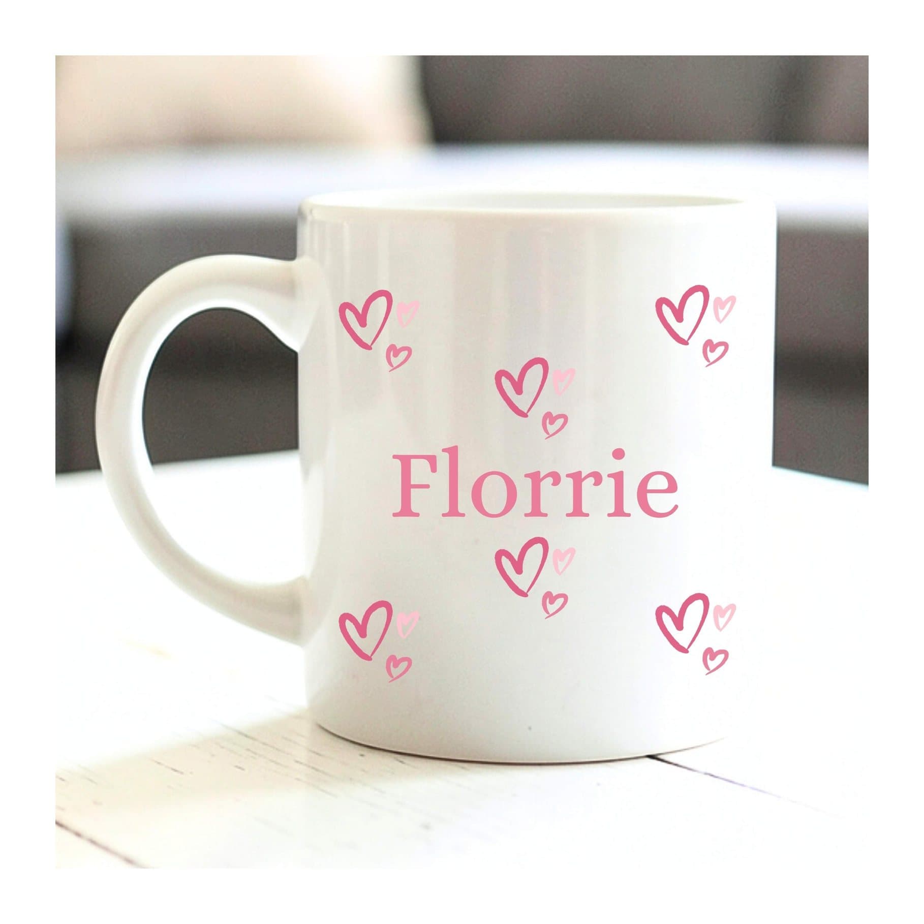 Pink personalised ceramic mug with a hearts design and a name space