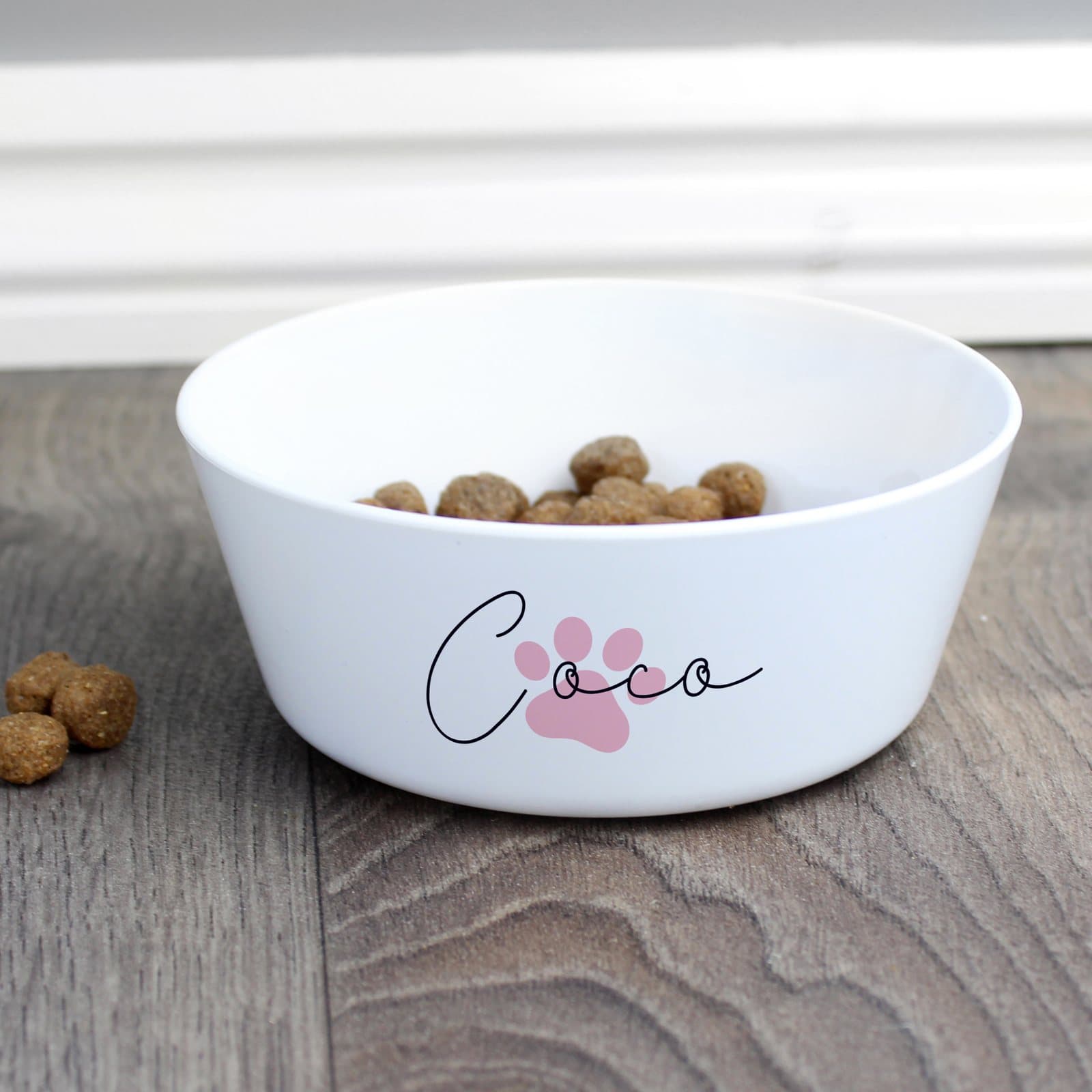 Pink plastic paw print cat bowl with a personalised name