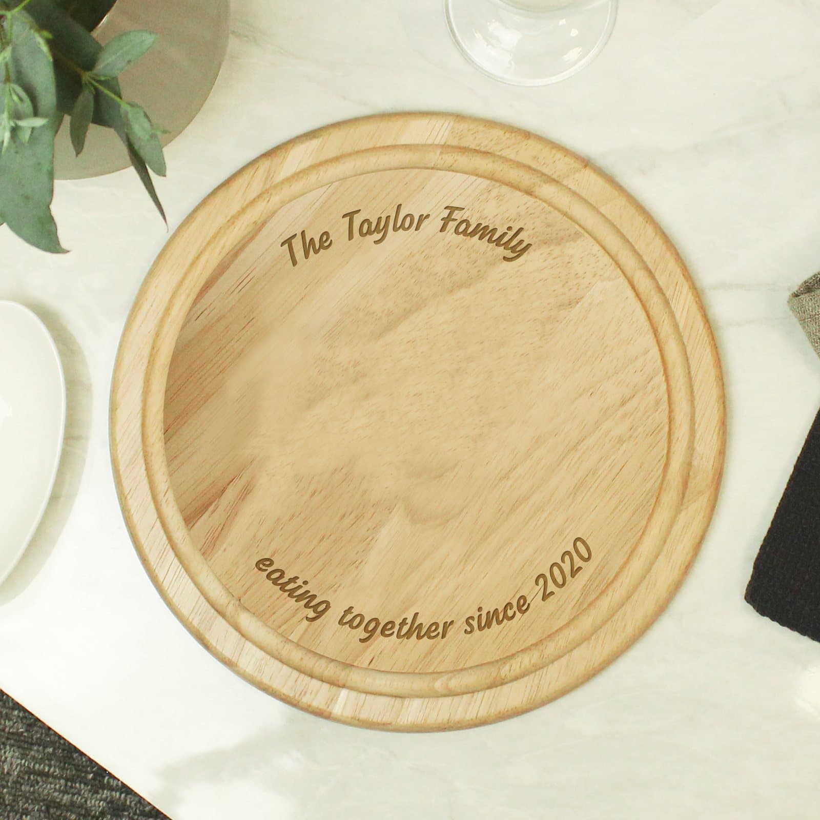 Plain round wooden chopping board with engraved text