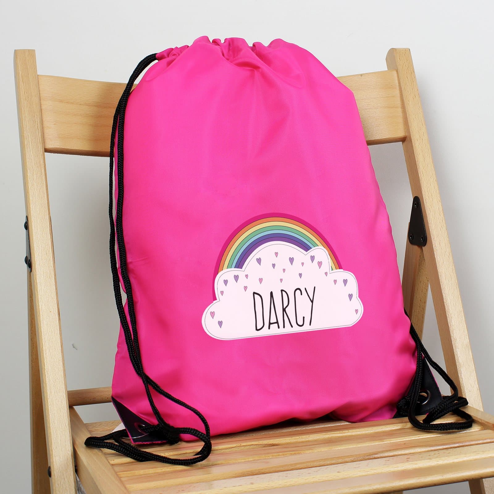 Pink drawstring kit bag with a rainbow design