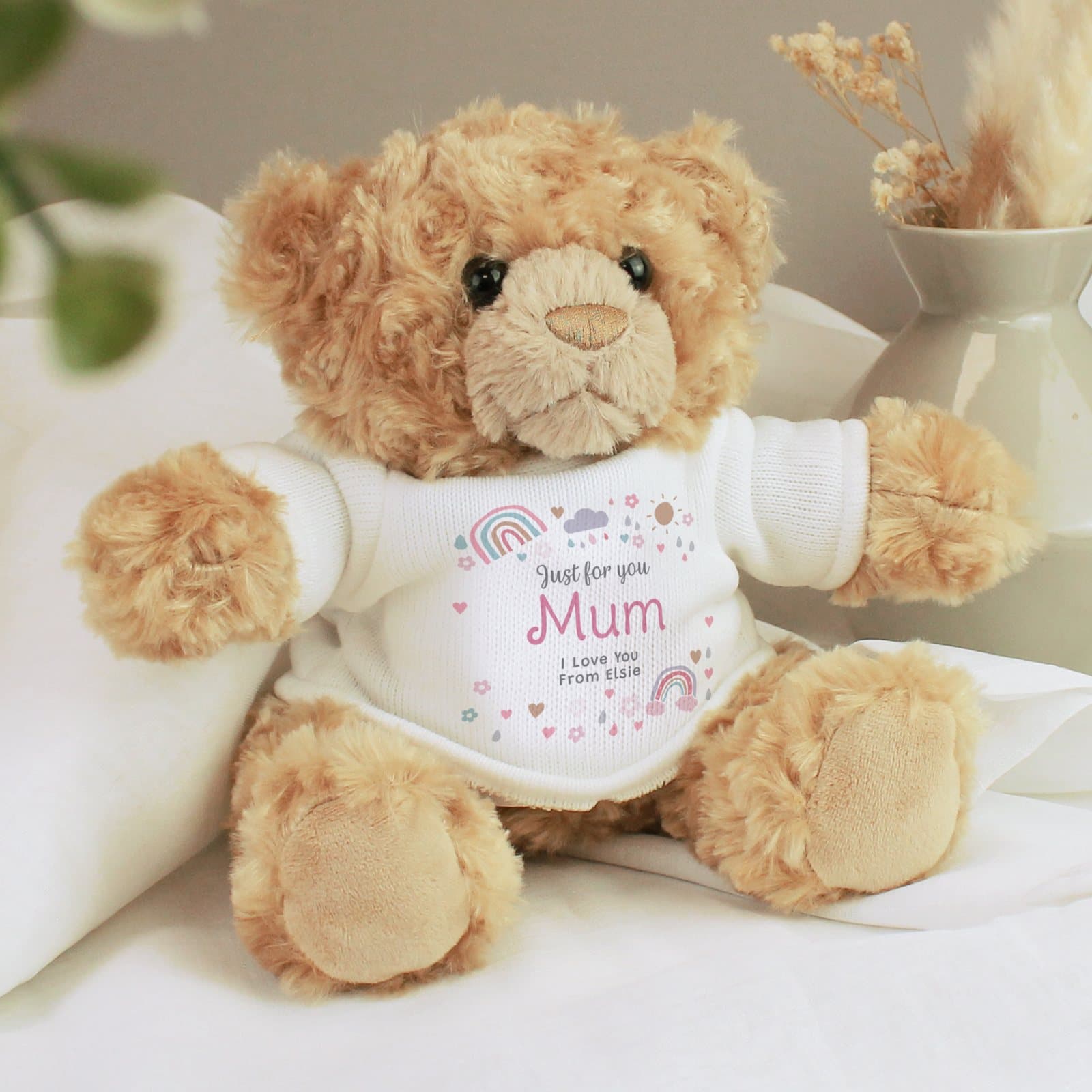 Plush teddy bear with a rainbows and sunshine design