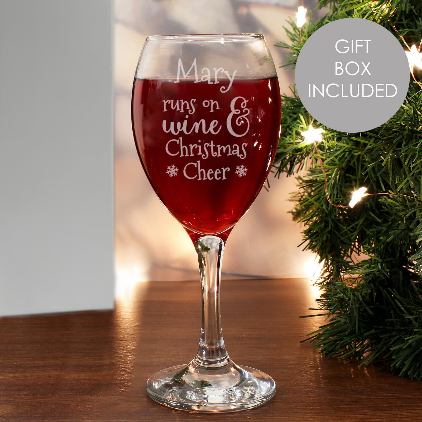 Wine glass with runs on wine and Christmas Cheer wording and a name