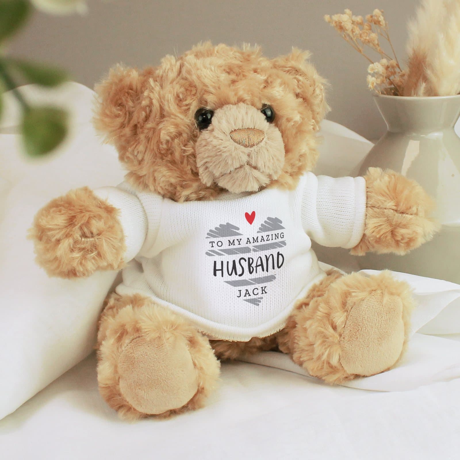 Plush teddy bear in a jumper with a scribble heart