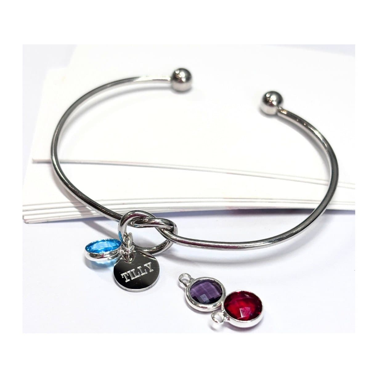 Silver plated birthstone charm bangle with a round disc and a coloured glass charm